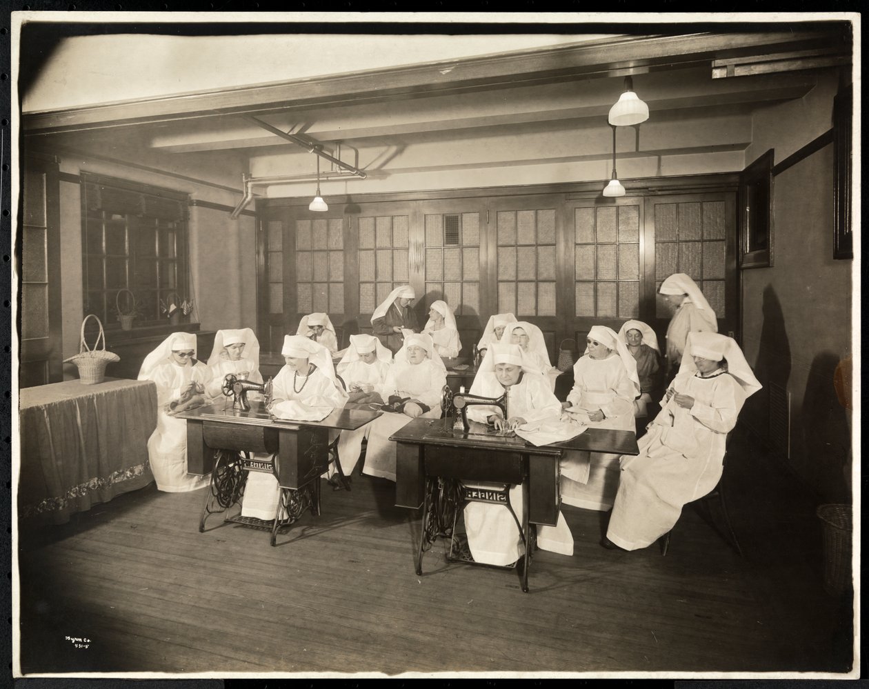 Kvinnor som bär vita smocks, i en syklass, förmodligen under eller i samband med första världskriget, New York, ca 1920 (silvergelatintryck) av Byron Company