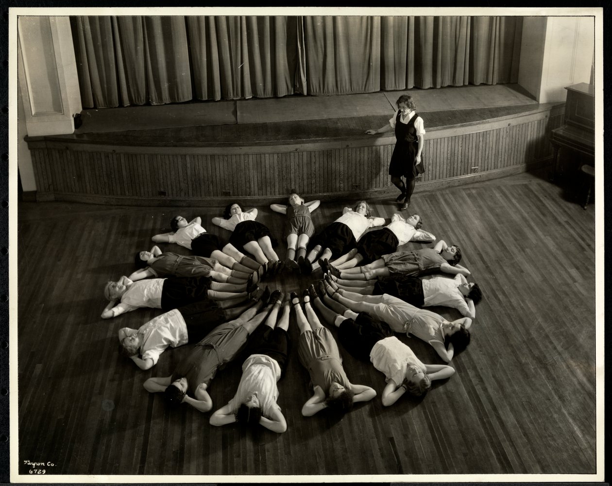 Unga blinda kvinnor som ligger i ett starburst-mönster på golvet i gymnastiksalen på New York Association for the Blind, 111 East 59th Street, New York, 1933 (silvergelatintryck) av Byron Company