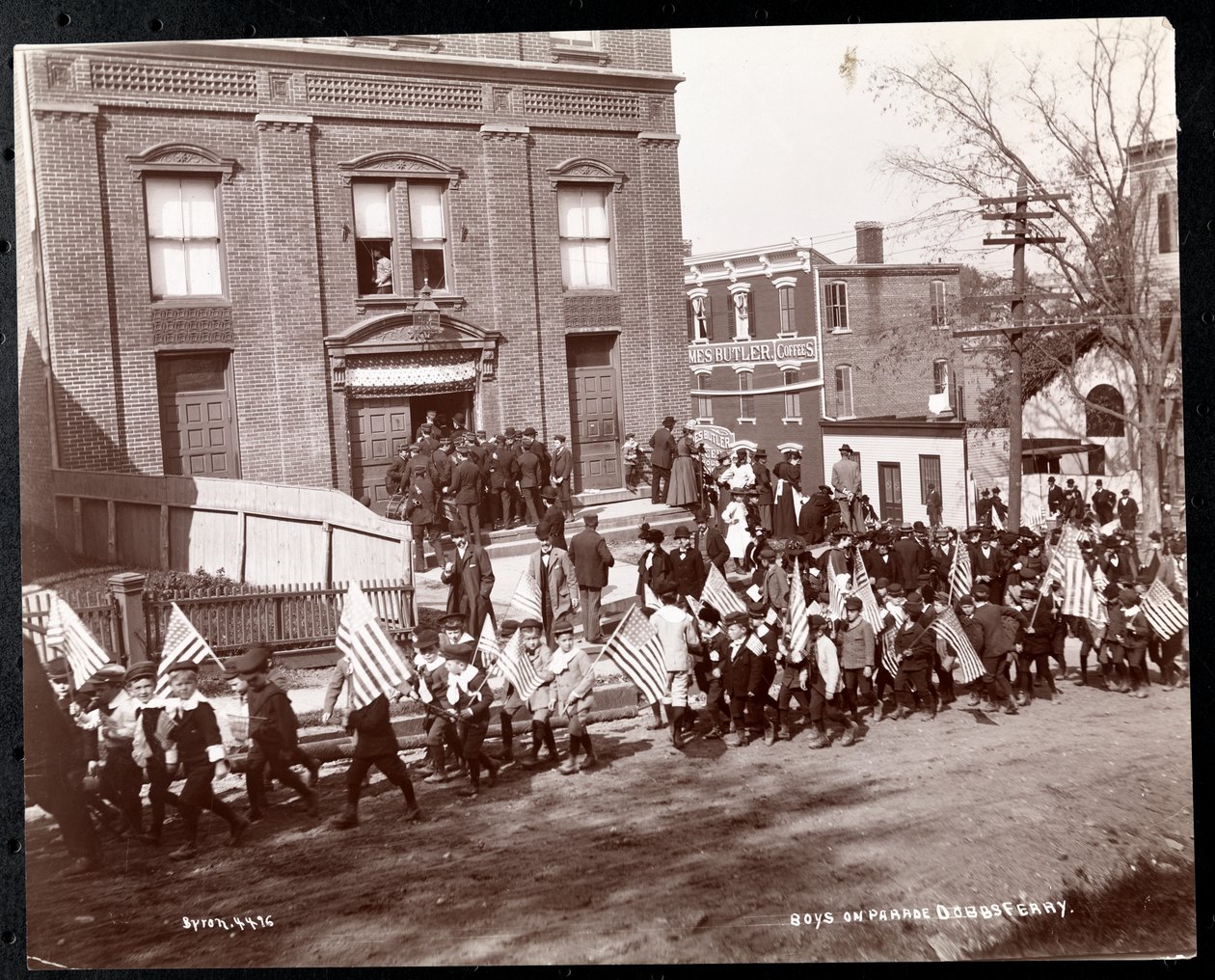 Unga pojkar med flaggor som marscherar i en parad vid Dobbs Ferry, New York, 1898 (silvergelatintryck) av Byron Company