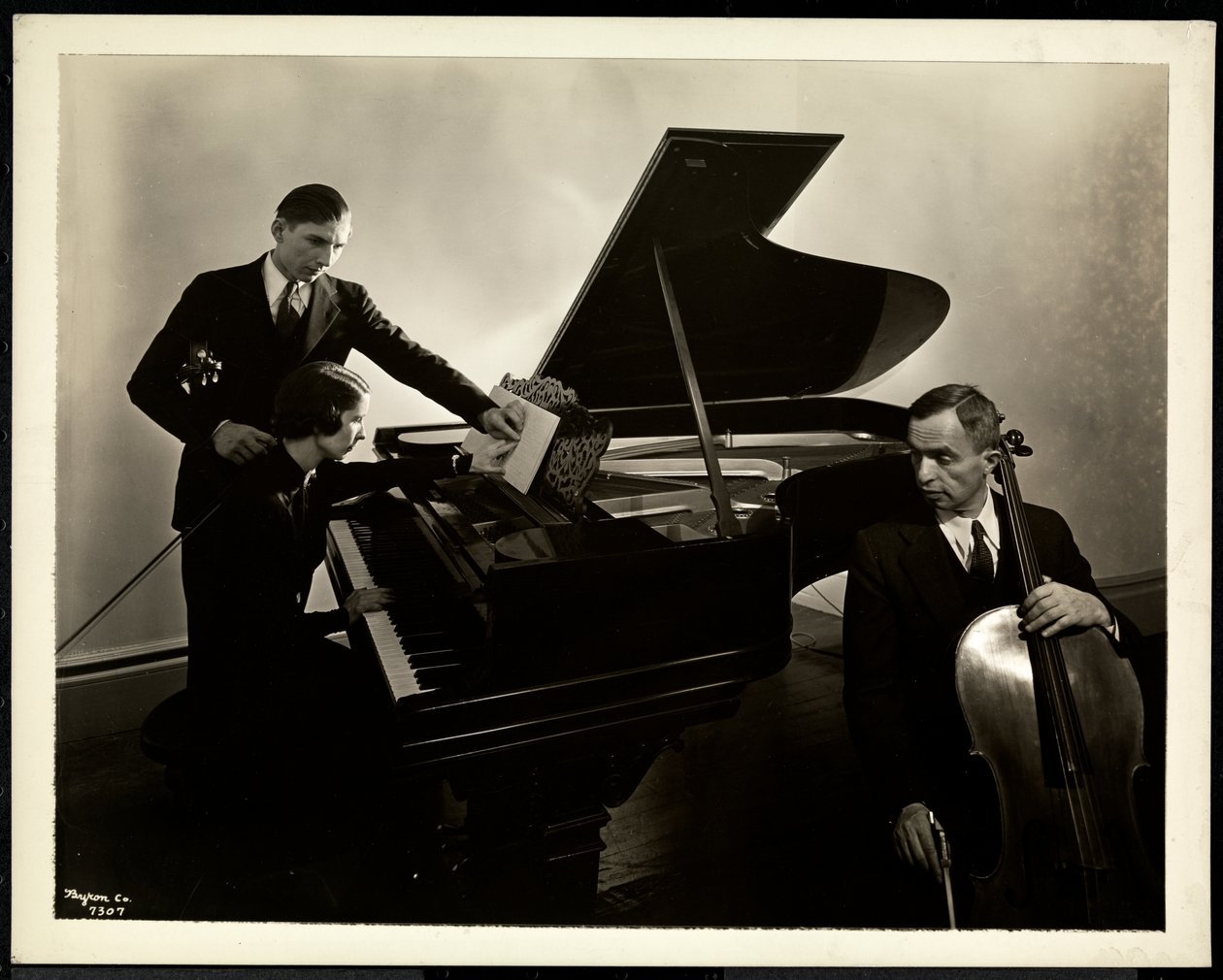 Blind kvinna, Miss Harding, vid pianot och instruerar två blinda män i fiol och cello, 1936 (silvergelatintryck) av Byron Company