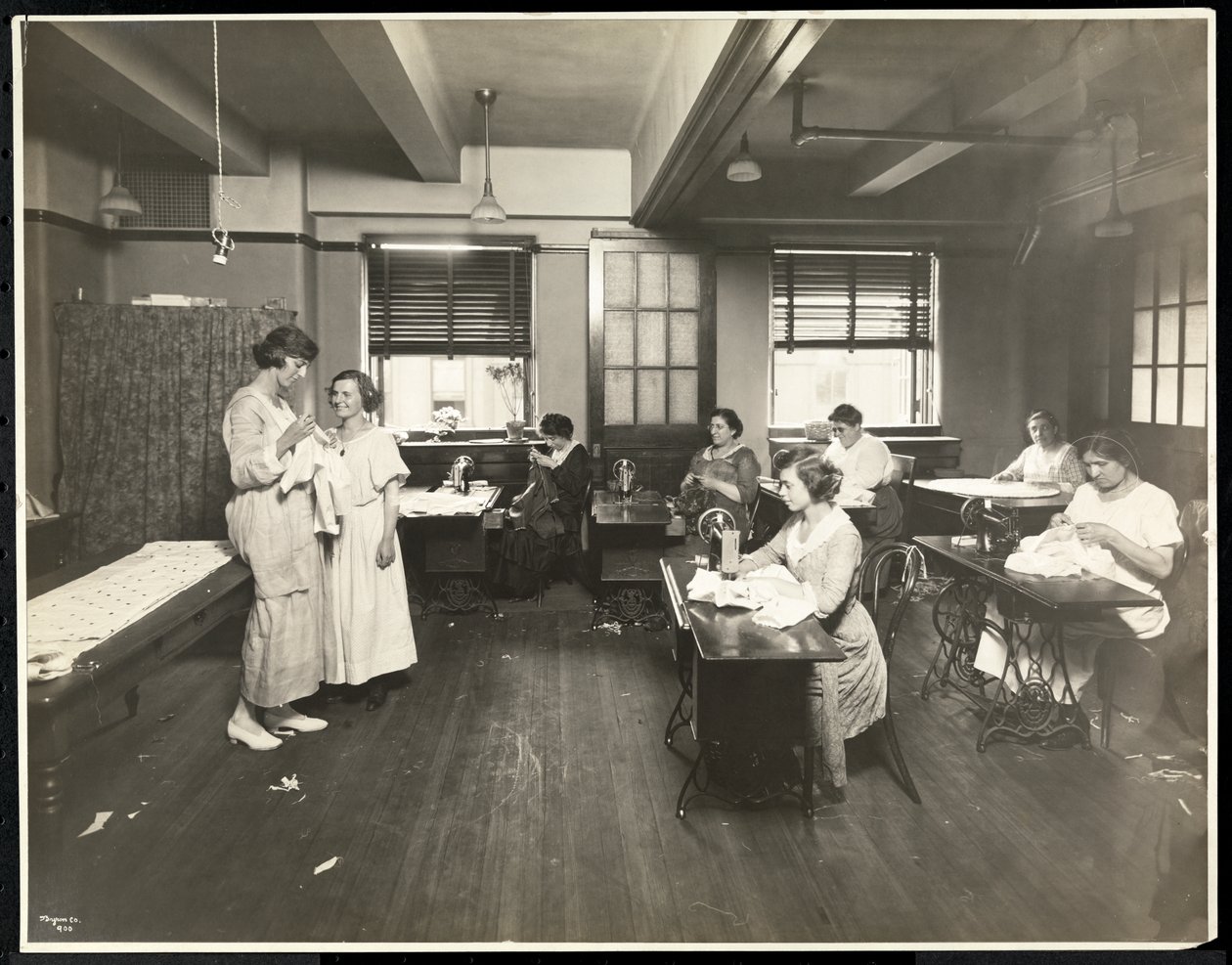 Blinda unga kvinnor och en lärare syr i ett klassrum på New York Association for the Blind, 111 East 59th Street, New York, 1921 (silvergelatintryck). av Byron Company