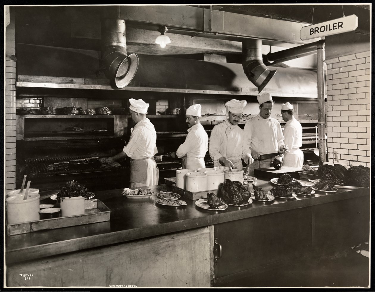 Kockar vid stekpannan i köket på Hotel Commodore, 1919 (silvergelatintryck) av Byron Company