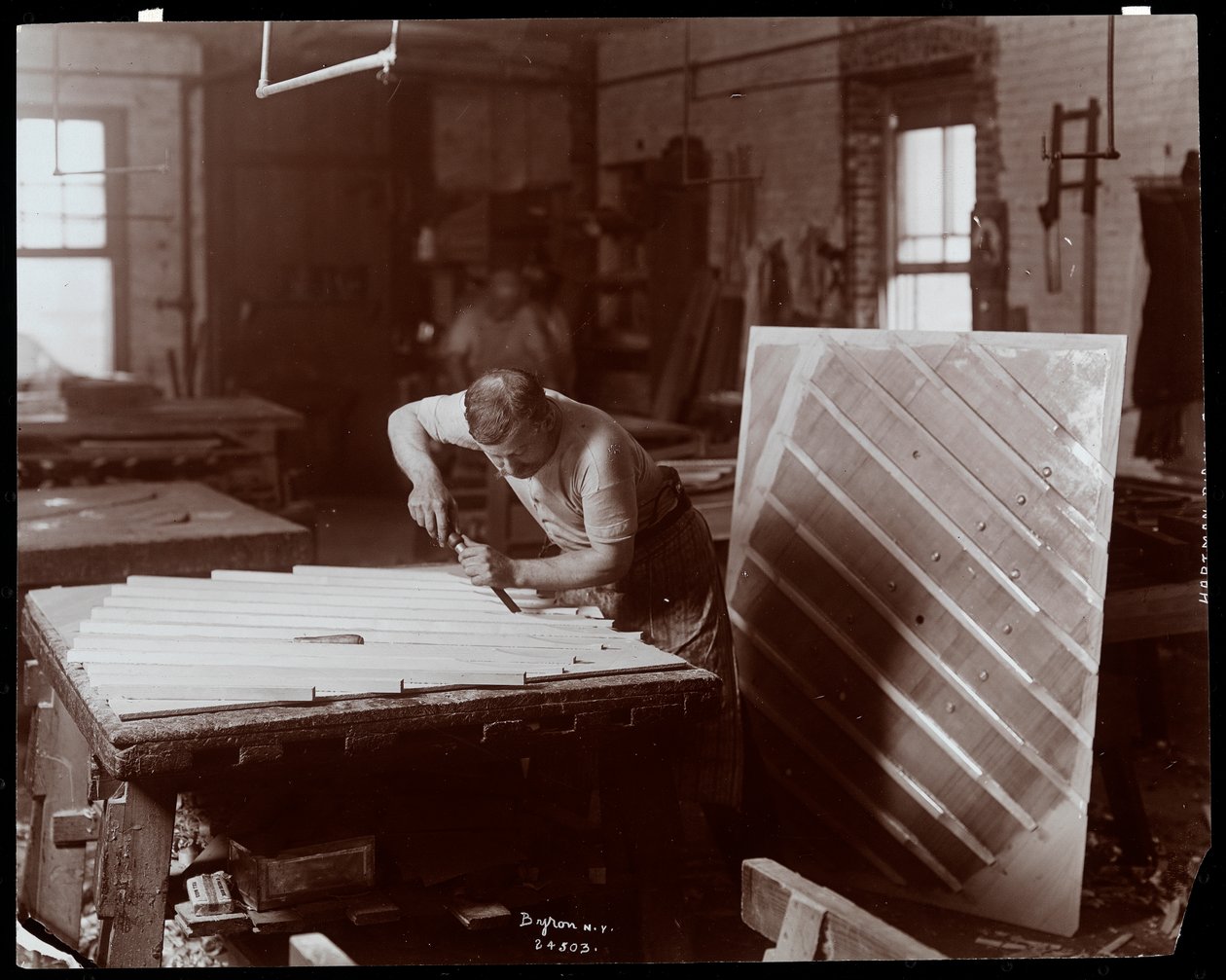 Man som arbetar i Hardman, Peck und Co. pianofabrik, New York, 1907 (silvergelatintryck) av Byron Company