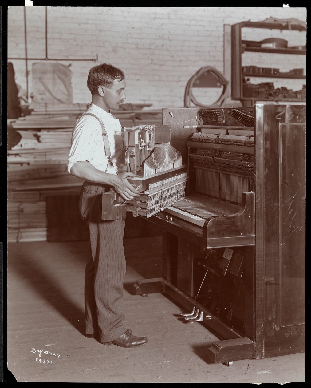 Man som arbetar i Hardman, Peck und Co. pianofabrik, New York, 1907 (silvergelatintryck) av Byron Company