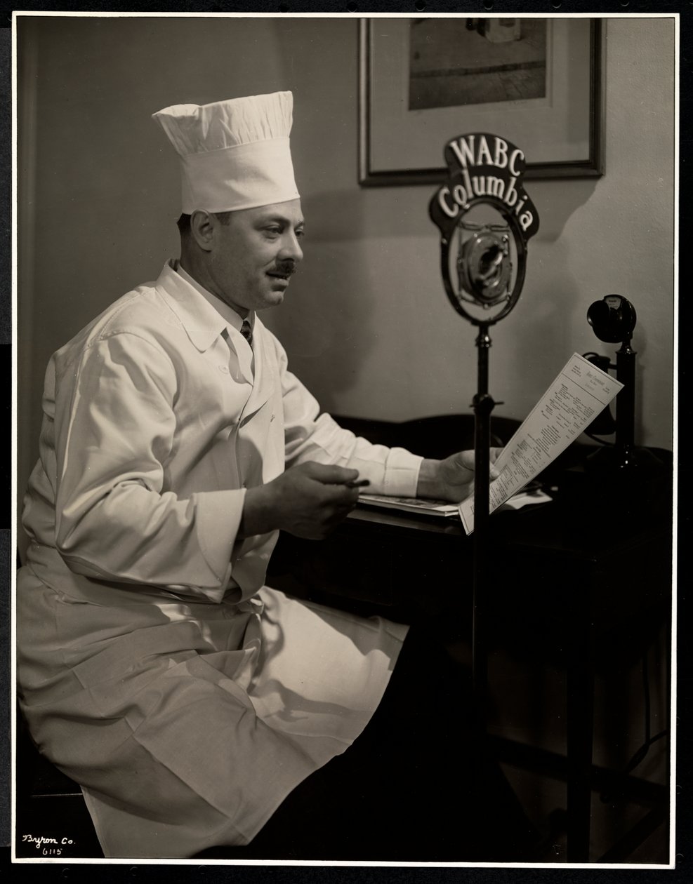 Porträtt av kocken Maurice Hervieux vid mikrofonen på Hotel Commodore, 1930 (silvergelatintryck) av Byron Company