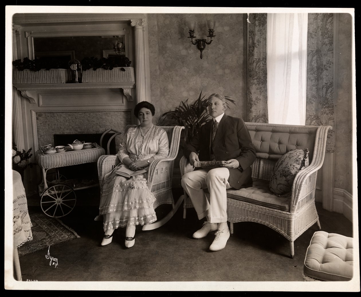Porträtt av Mr. och Mrs. Howard sittande poserade i ett vardagsrum i deras hem på 200 5th Avenue, New York, 1916-6 (silvergelatintryck) av Byron Company