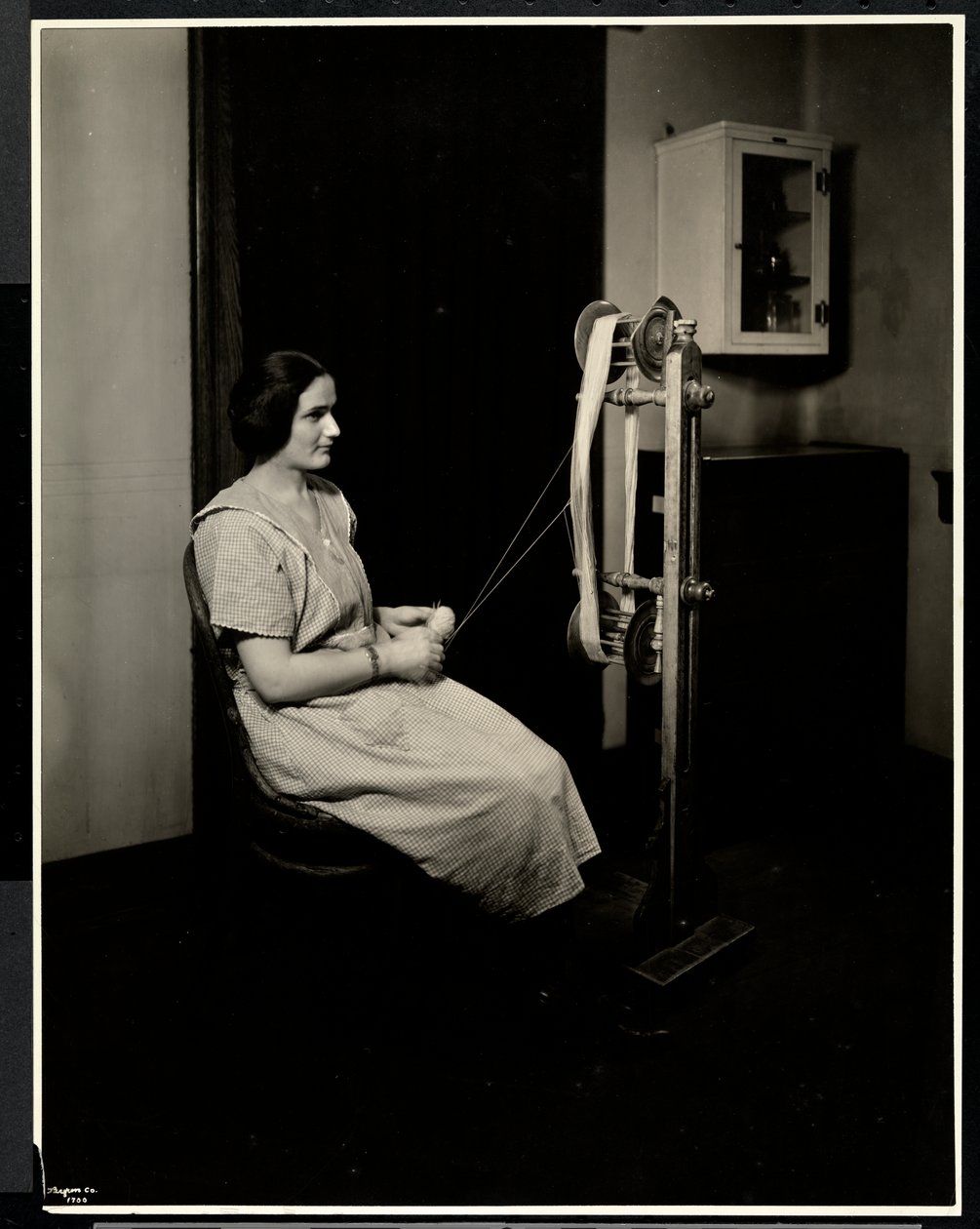 Porträtt av en blind, dövstum och stum ung kvinna som spinner ull på New York Association for the Blind, 111 East 59th St., New York, 1923 (silvergelatinprint) av Byron Company