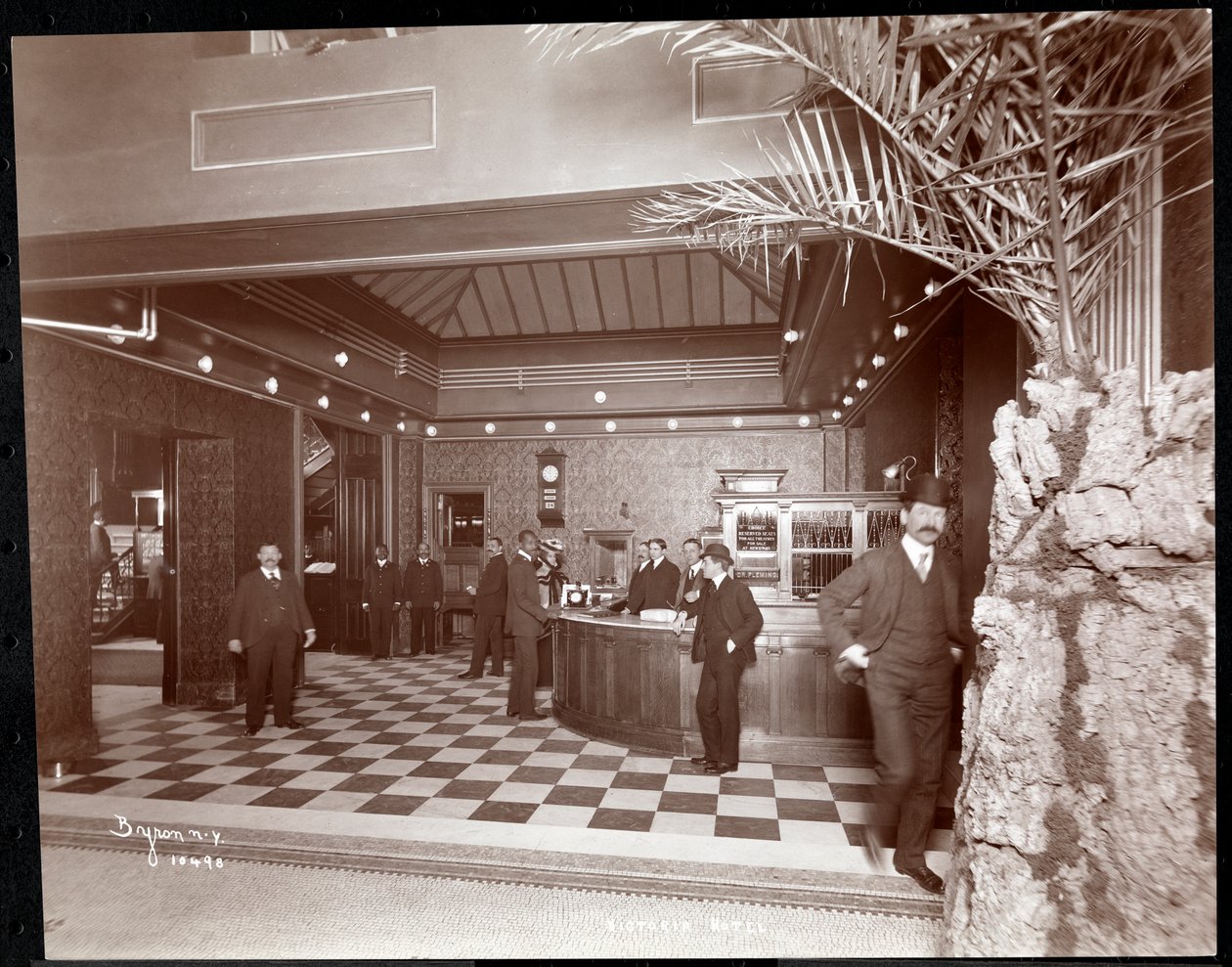 Lobbyn och registreringsdisken på Hotel Victoria, 1900 eller 1901 (silvergelatintryck) av Byron Company