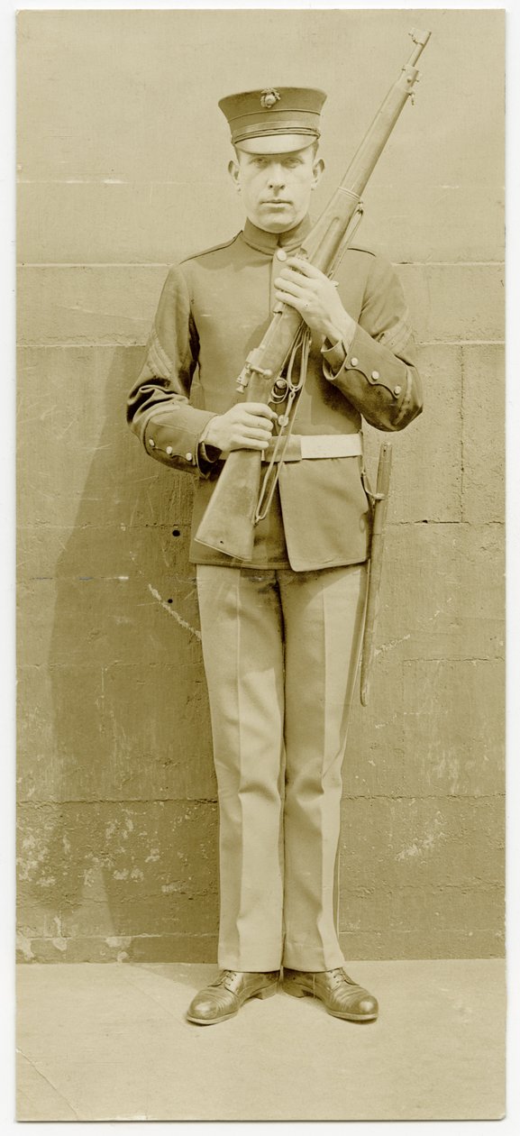 Uniformed Soldier Posing For a Picture in Front of a Concrete Wall av Carl Michel