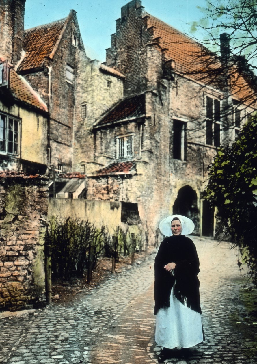 Nederländerna, provinsen Zeeland. Kvinna framför Kuipers-portalen i staden Middelburg. Bilddatum: cirka 1920. Carl Simon-arkivet av Carl Simon