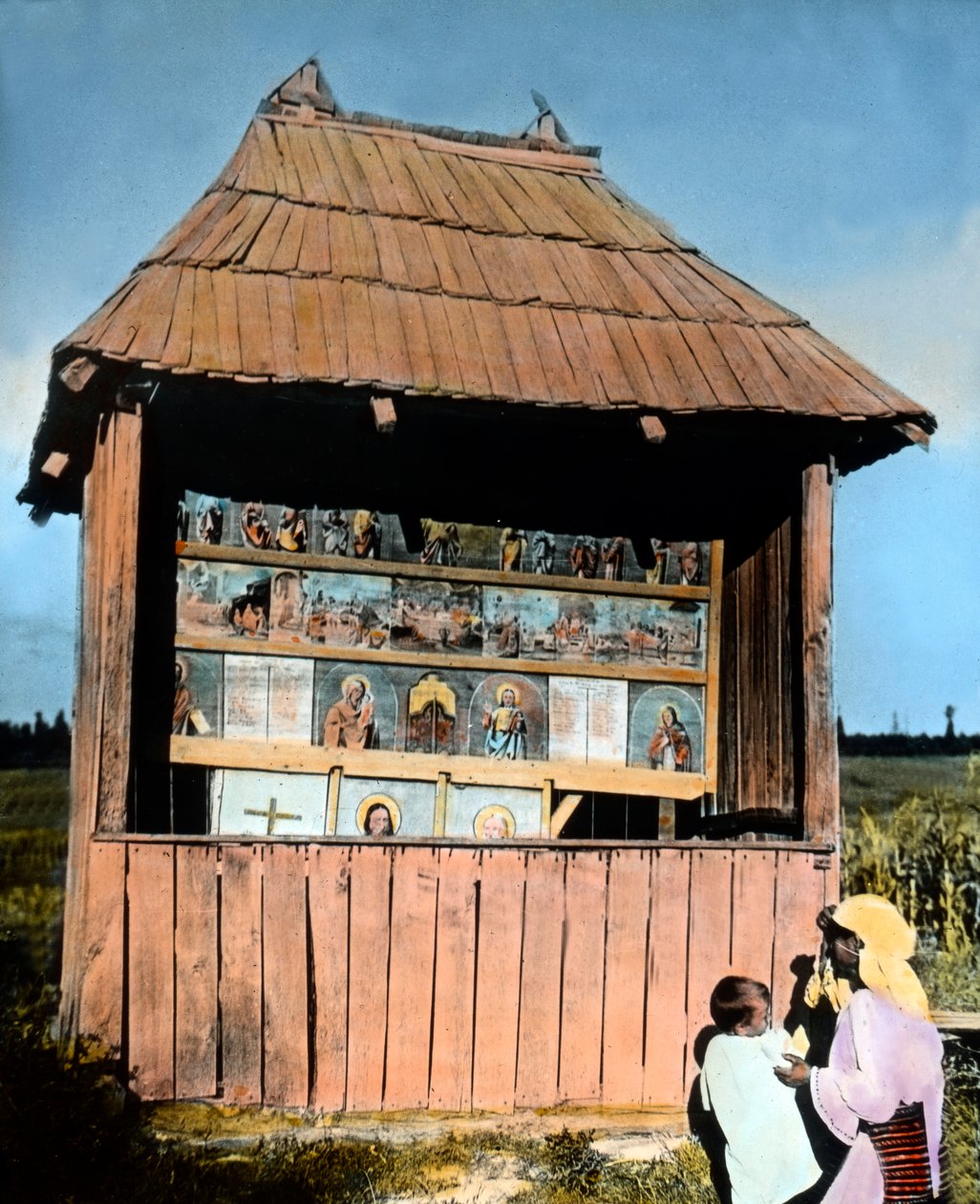 Rumänien, Bukovina, mor med barn framför ett litet kapell med bilder av helgon, bilddatum: ca 1920. Carl Simon-arkivet av Carl Simon