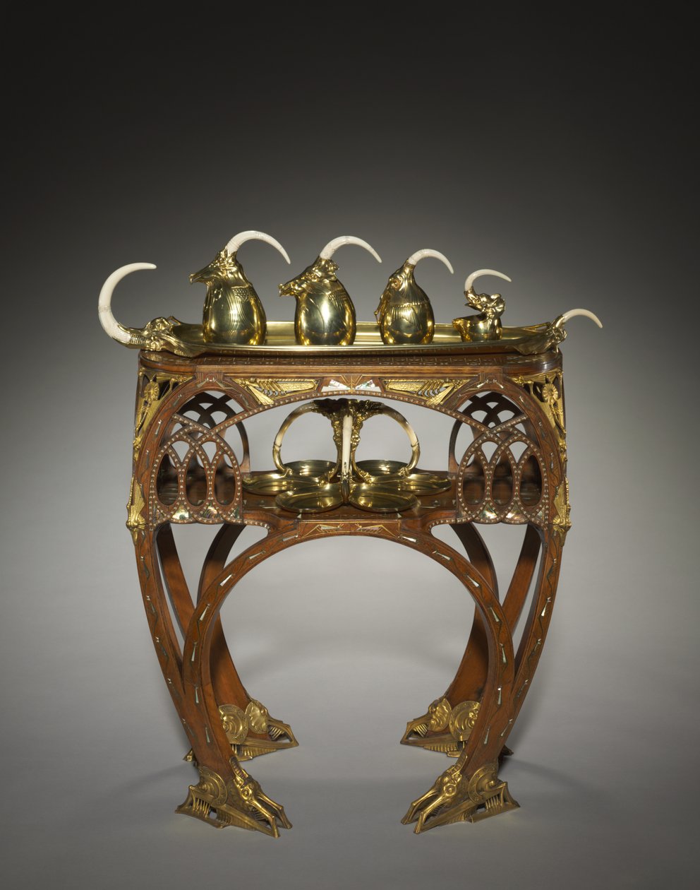 Bricka med gräddkanna, täckt sockerskål, tekanna, varmvattenkruka och salver, utförd av Adrien-Aurélien Hebrard (1866-1937), och bord, ca 1907 (inlagt trä (mahogny?), gjutna och förgyllda bronsfästen, inlägg av elfenben eller ben, metall och pärlemor (mar av Carlo Bugatti