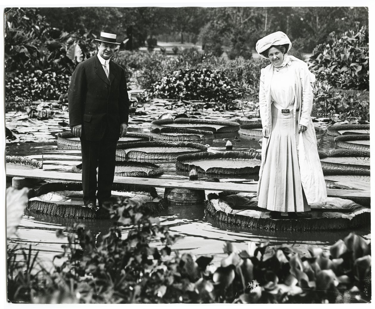 Tower Grove Park Lily Pond. Man and woman standing on Lily Pads. av Charles Clement Holt