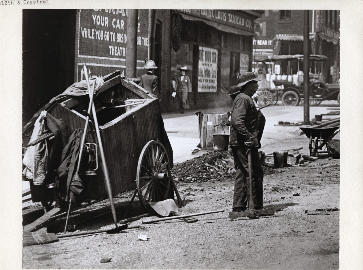 Worker pausing during street work near the southwest corner of Chestnut Street and 12th Street, now Tucker Boulevard av Charles Clement Holt
