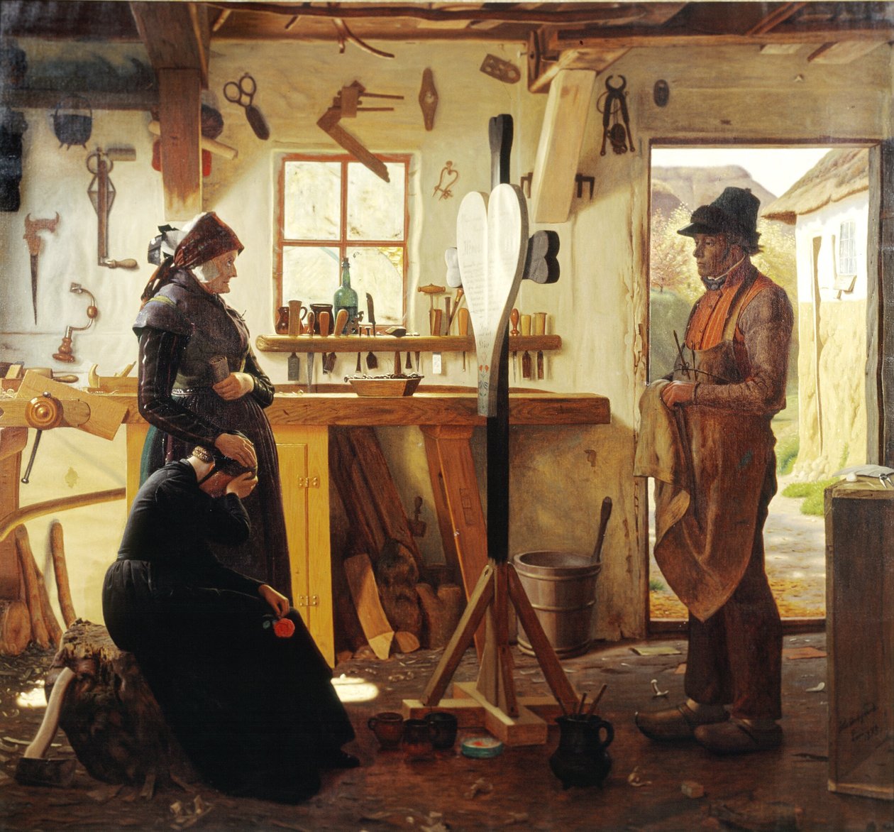 Två kvinnor besöker bykonstnären för att se det beställda gravkorset av Christen Dalsgaard