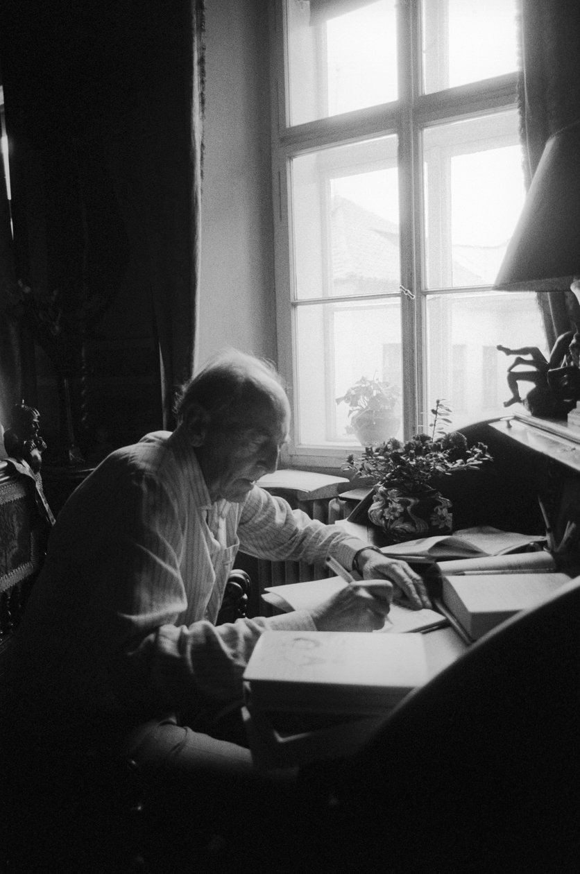 Jiri Mucha sitter vid sitt skrivbord i sitt hus i Hradcany, Prag av Czech Photographer
