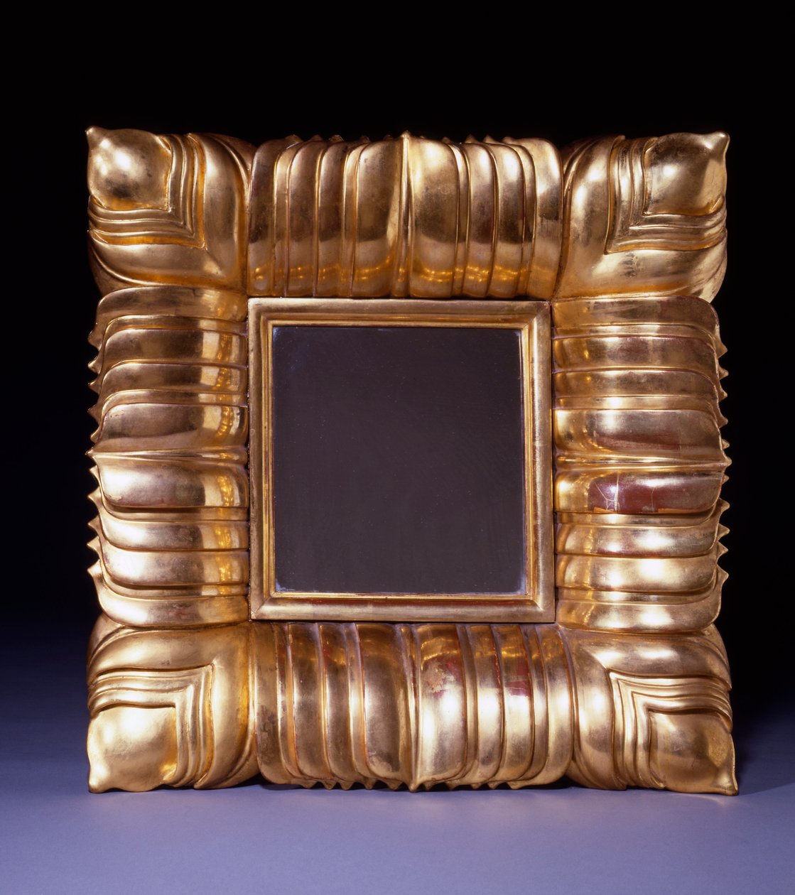 En spegel av förgyllt trä, designad av Dagobert Peche (1887-1923), snidad med överlappande stiliserade bladblad, ca 1925 (förgyllt trä) av Dagobert Peche