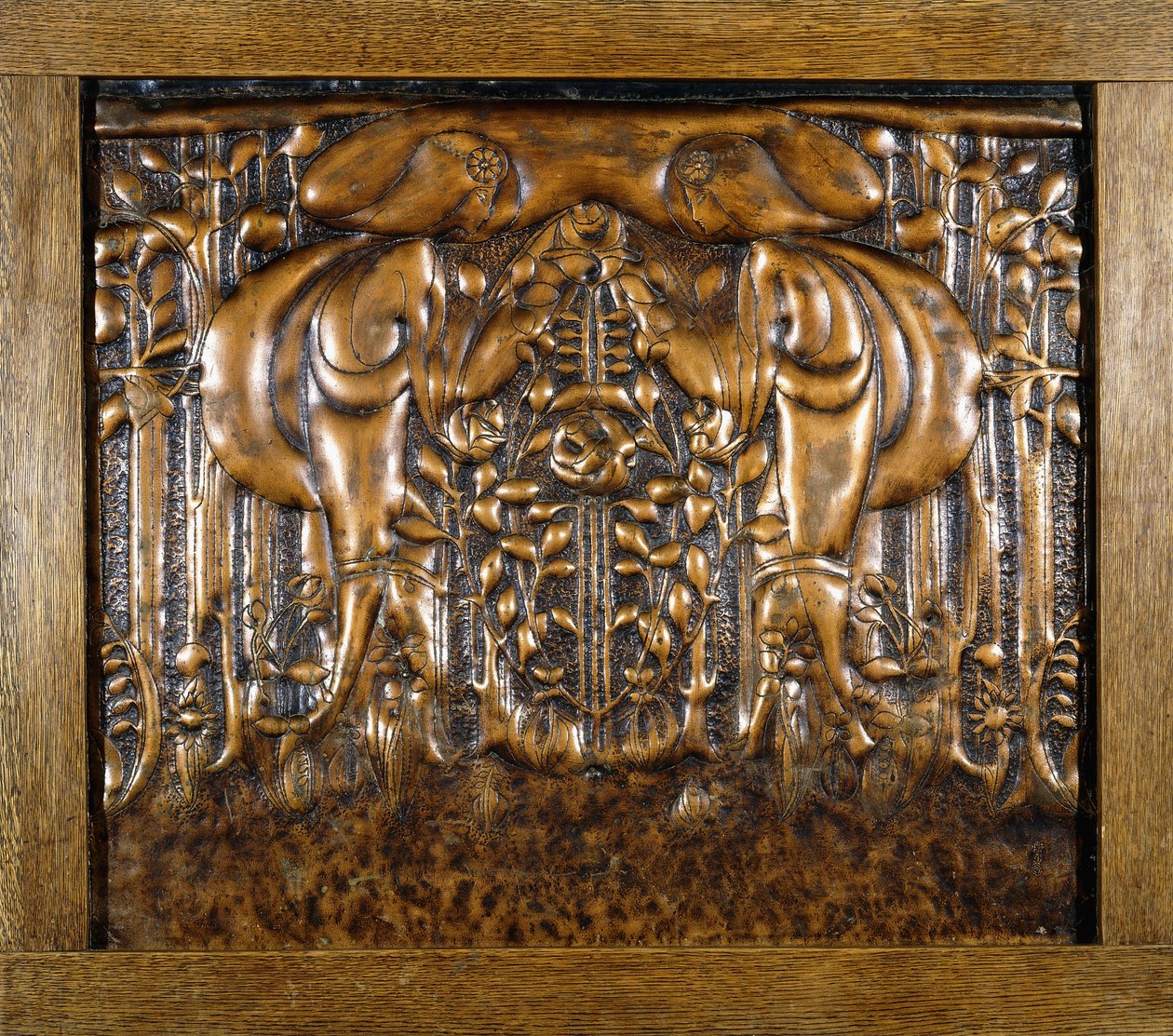 En dekorativ blypanel gjuten i hög relief, föreställande två vända stiliserade jungfrur av Donald McKay Stoddart