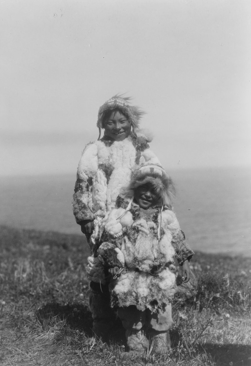 Ett litet barn och en äldre Eskimo som bär anka hudparkas, Nunivak Island, Alaska, c.1929 (b/w foto) av Edward Sheriff Curtis