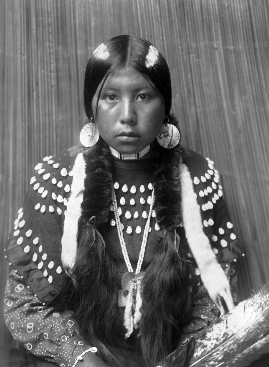 Kalispel indisk kvinna, vita ränder målade på håret, örhängen med skalskivor, klädd filtklänning dekorerad med älgtänder, ca. 1910, foto Edward S. Curtis av Edward Sheriff Curtis