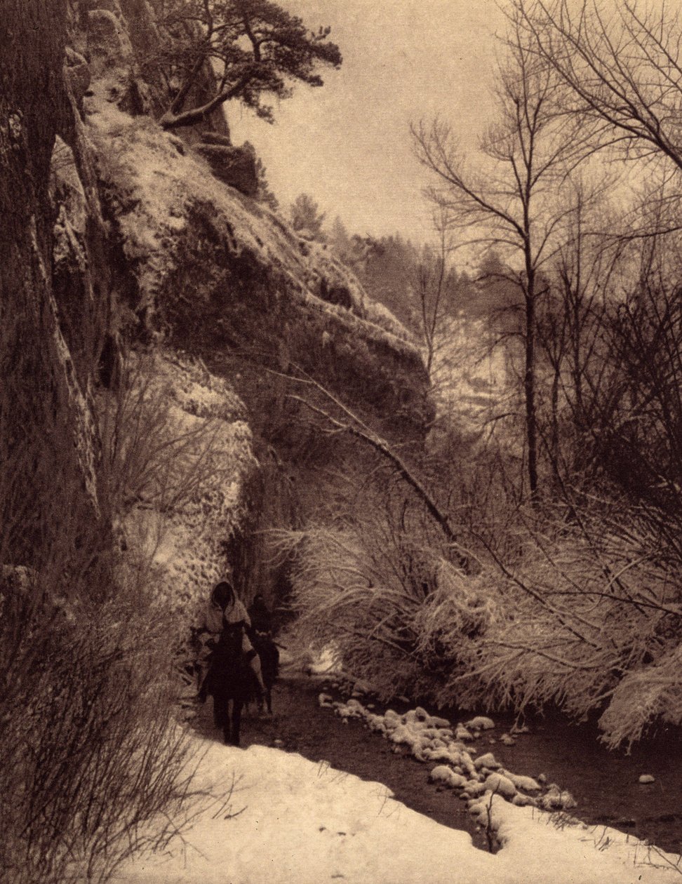 Passerar klippan, vinterscenen. Apsaroke-indianer som rider längs en klippa i snön på Pryor River, Montana. Foto taget från volym 4 av uppslagsverket publicerat av Edward S. Curtis (1868-1952) om indianerna i Nordamerika, med ett förord av Theo av Edward Sheriff Curtis
