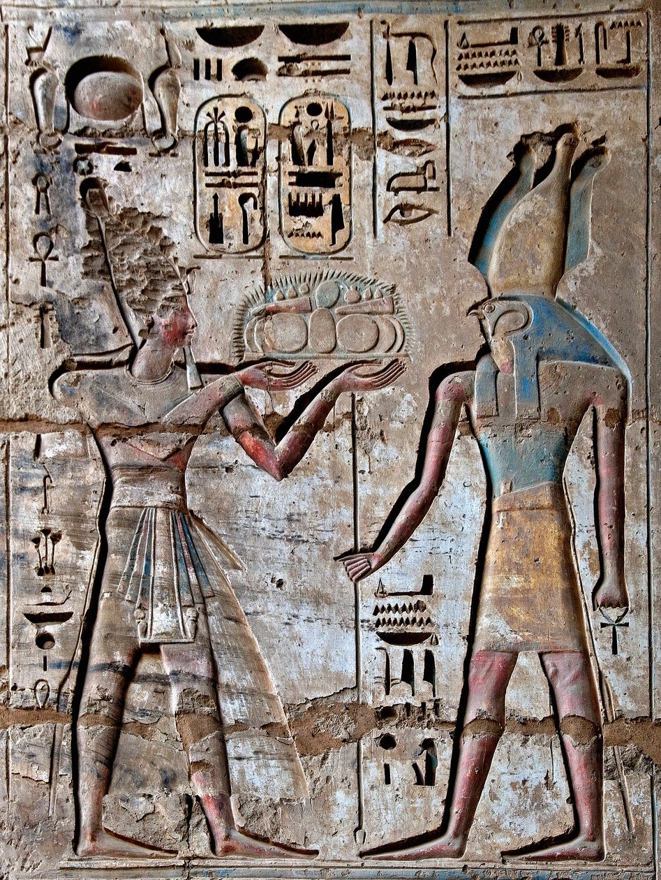 Egyptisk antikvitet: första domstolen, detalj av målade reliefer som visar farao som bär offergåvor till den gudomlige Horus. Ramses III:s begravningstempel (1187-1156 f.Kr.). Luxor, Medinet Habou, Egypten av Egyptian 20th Dynasty
