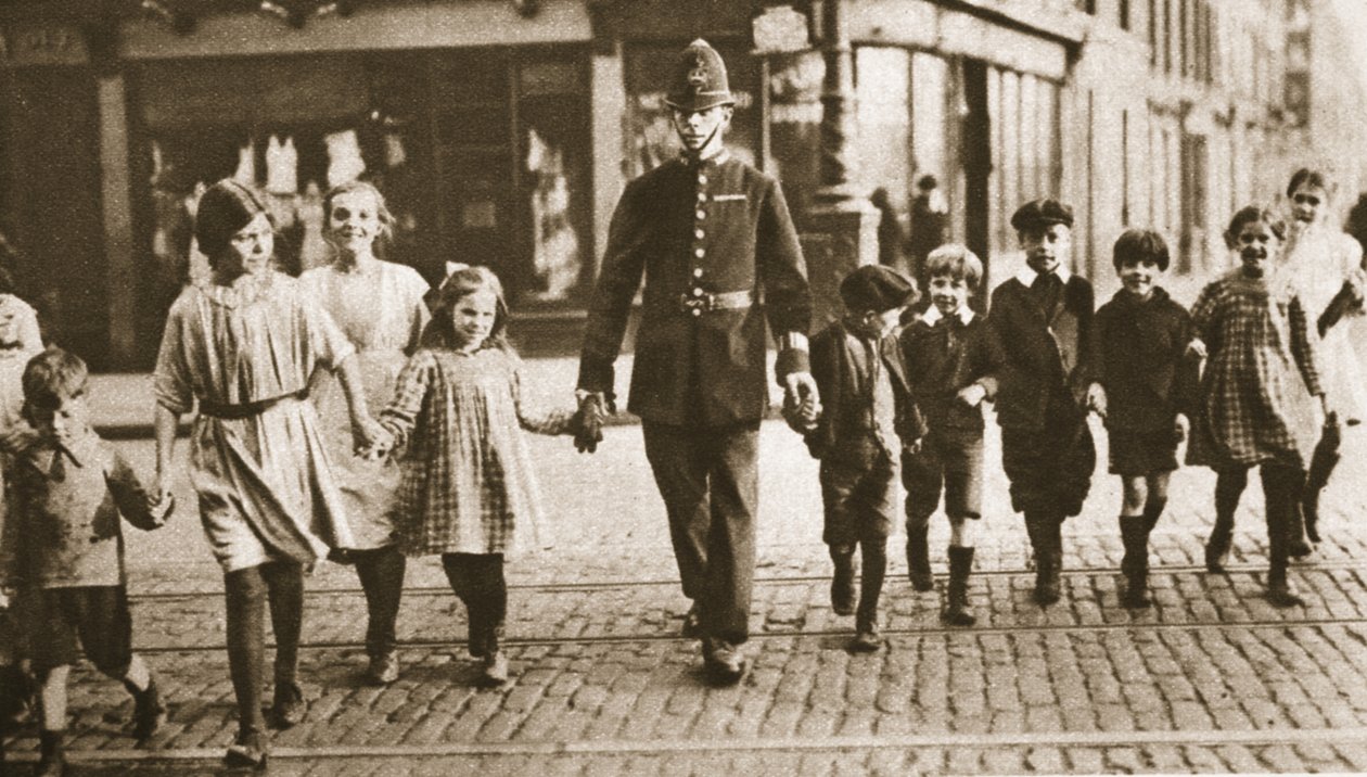 En bobby på takten som hjälper barn över gatan i slutet av skoldagen, från Wonderful London, publicerad 1926-27 (fotogravyr) av English Photographer