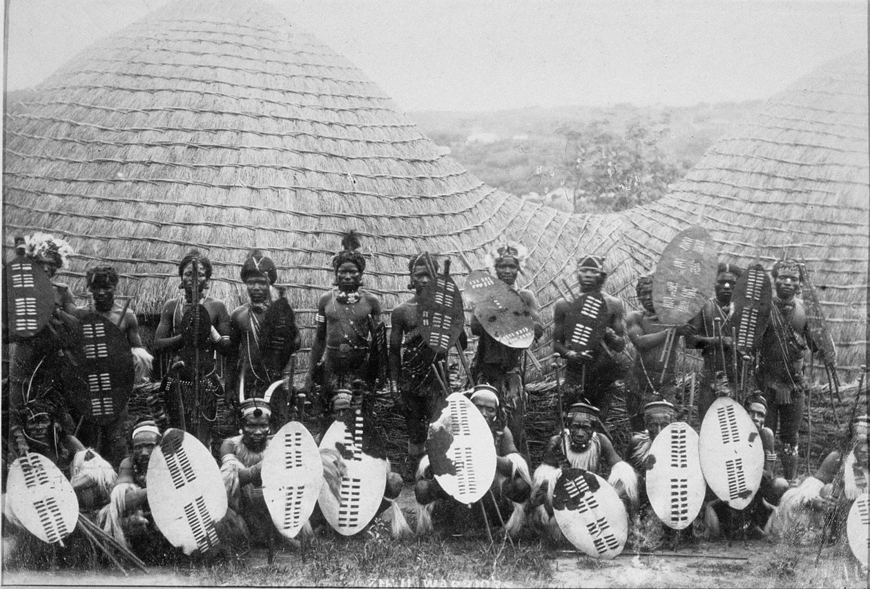Gruppporträtt av Zulu Warriors utanför en hydda, ca 1875 (albumintryck) av English Photographer