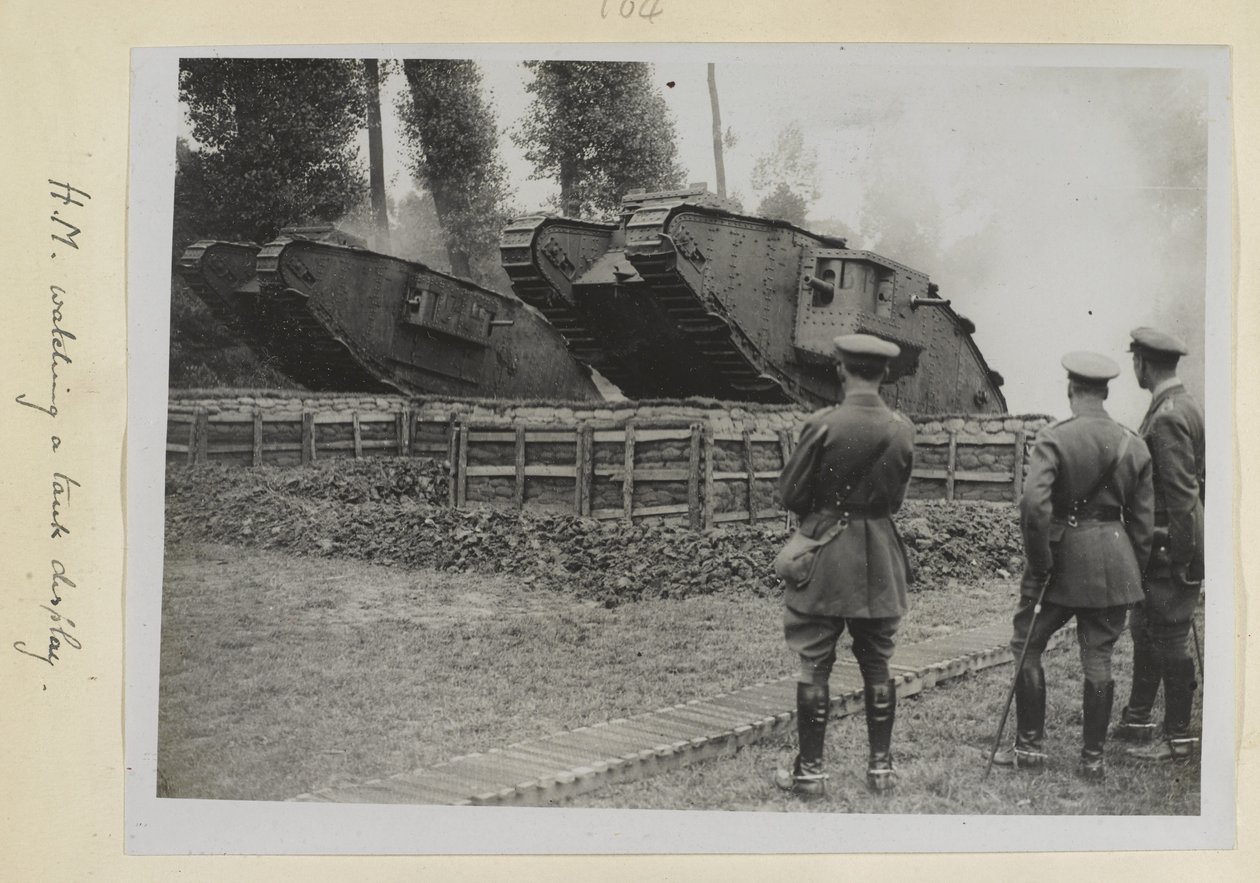 Tre officerare, en möjligen kung George V, såg två stridsvagnar köras över ett hinder, 1915-18 av English Photographer