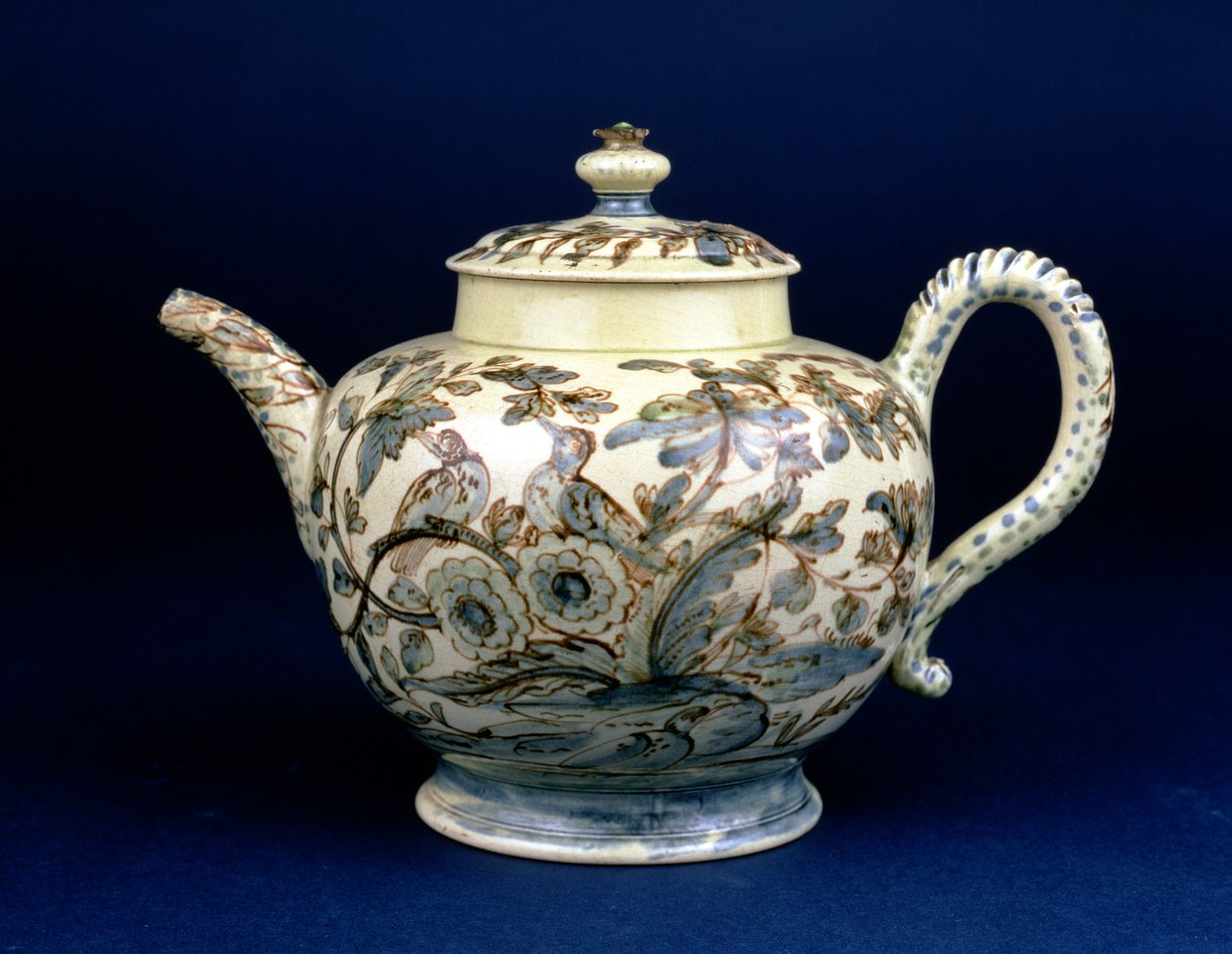 Staffordshire Creamware tekanna känd som The Tunstall Teapot dekorerad med tre fåglar i orientaliskt blad, målade i brunaktig mangan konturerna förhöjda i blått och grönt underglasyr av F. Morg av English School