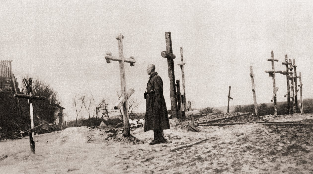En rysk soldat vid en vapenkamrats grav under första världskriget, från The Illustrated War News, 1915 av English Photographer