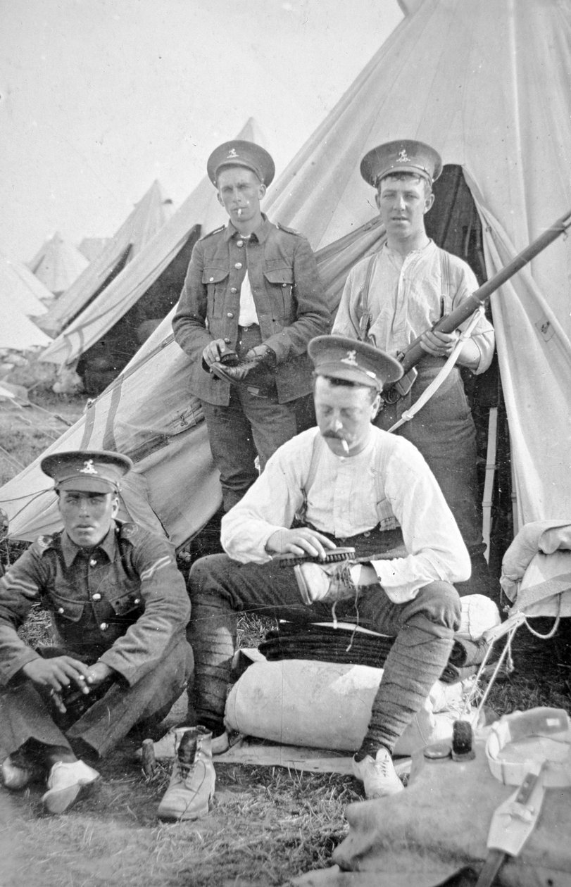 Brittiska soldater i lägret städar sitt kit av English Photographer