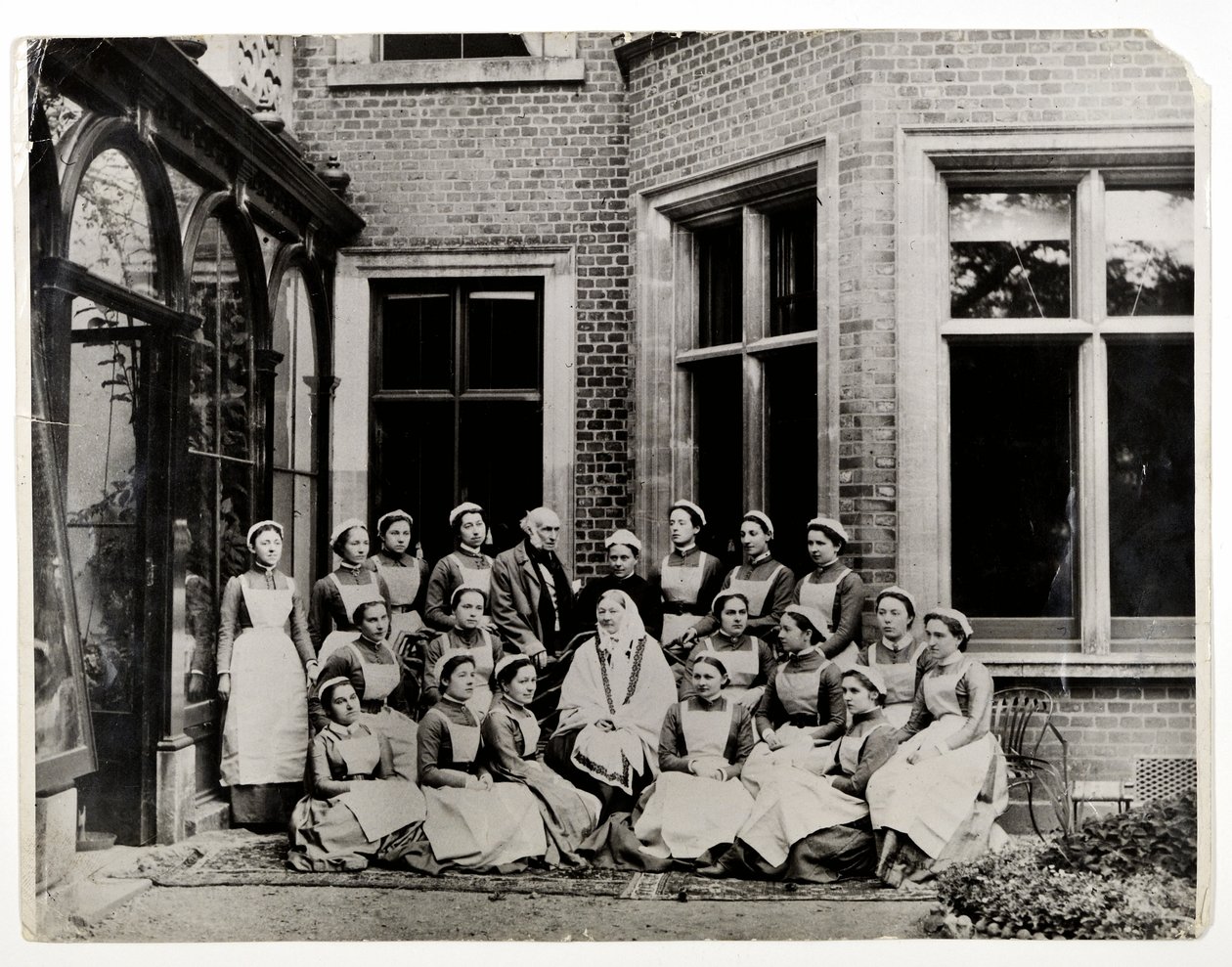 Florence Nightingale med Sir Harry Verney och Miss Crossland, i mitten av en grupp sjuksköterskor på Claydon House, 1886 av English Photographer