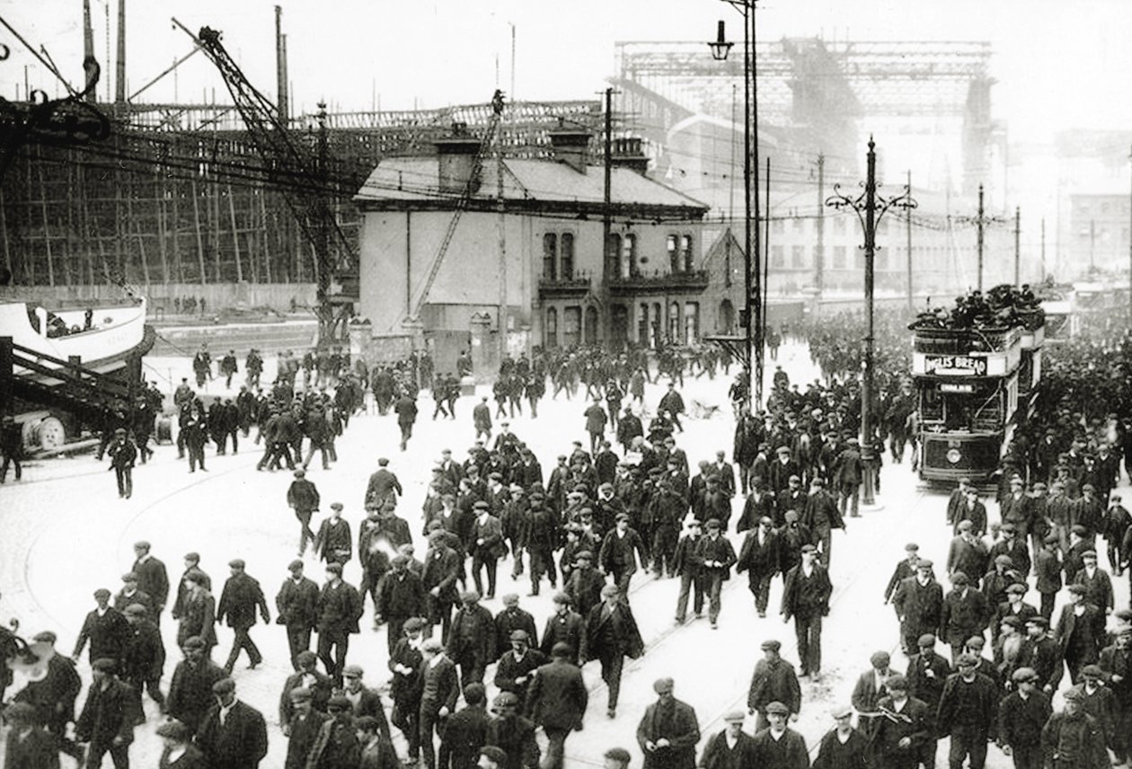 Avstängningstid vid Harland and Wolff-varvet, Belfast, Irland med Titanic under konstruktion i bakgrunden, 1910-11 av English Photographer