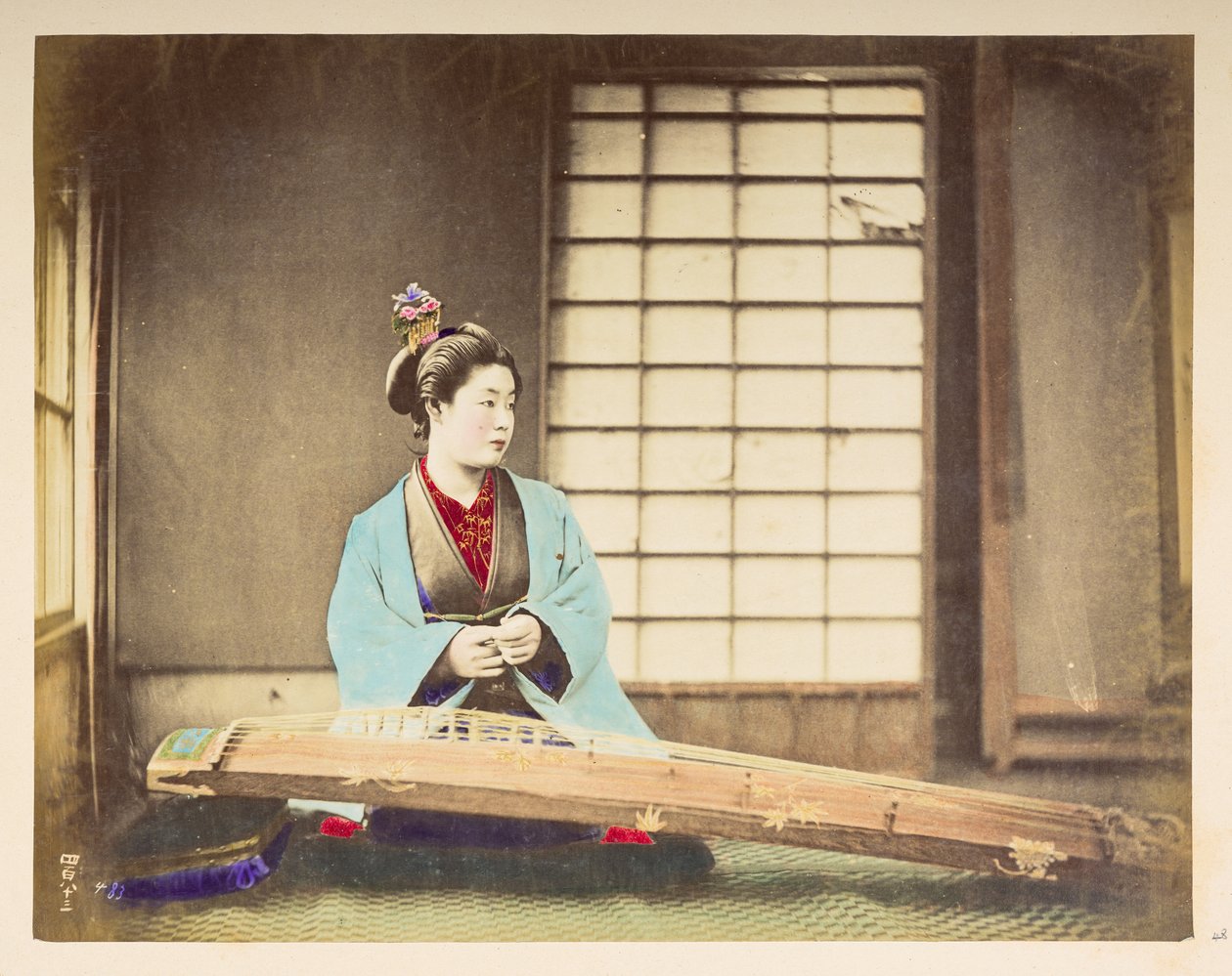 Sjungande tjejer [Japan], Studioporträtt av en japansk kvinna, sittande med ett stränginstrument (ett slags cittra) vilande på golvet framför henne,  Fotograf: Okänd  Lucas Collection: Fotografiskt rekord från Charles James och Mo världsturné av English Photographer