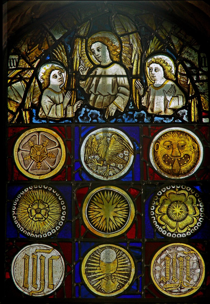 En panel i det östra fönstret som visar änglar ovanför 9 rundlar med solstrålar, rosor, ett leopardhuvud, en kalk och monogram av English School