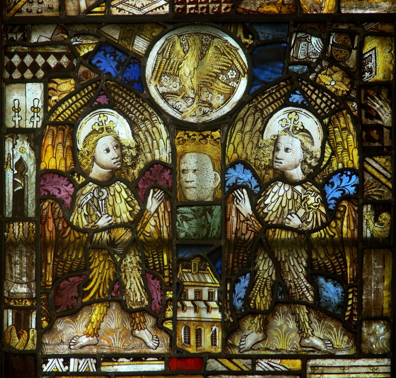 En panel i det östra fönstret som visar fjäderbeklädda änglar med passionsinstrument: även St Johns eagle bland fragment av English School