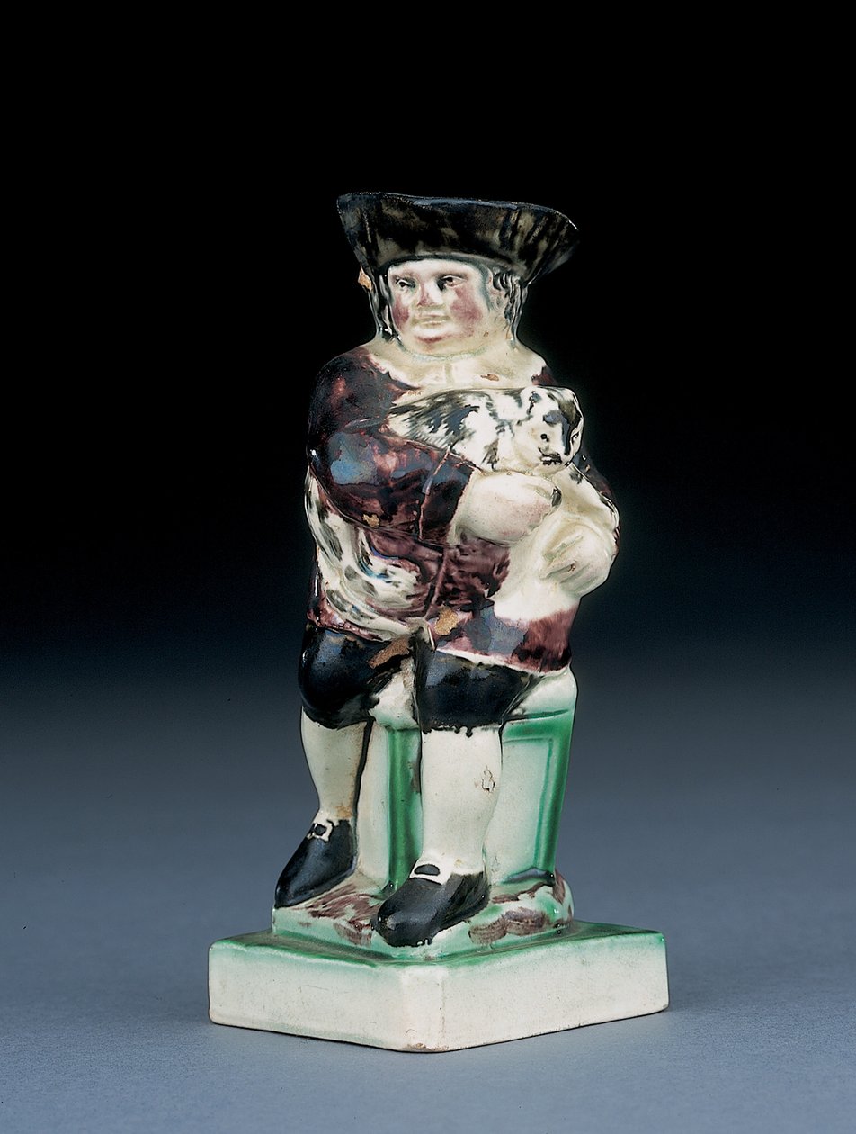 Dick Whittington-kanna, formgjuten reser sig från en stol med hög rygg, håller sin katt, plaskad i bruna, gröna och svarta kläder, en formgjuten sköld vid hans sida, ca 1790 av English School