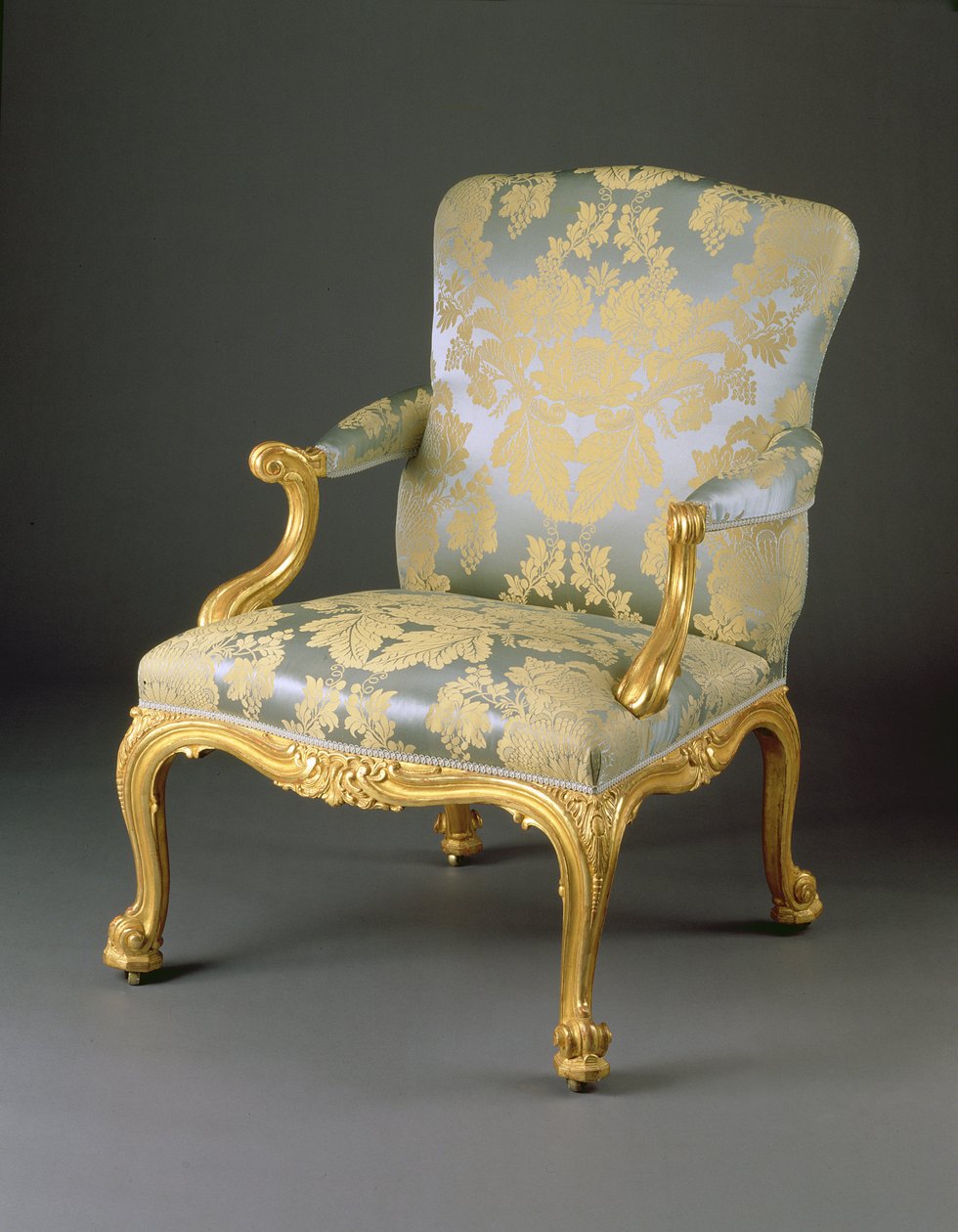 En från en uppsättning av fyra George III-fåtöljer, ca 1765 (snidat förgyllt trä och klädsel) av English School