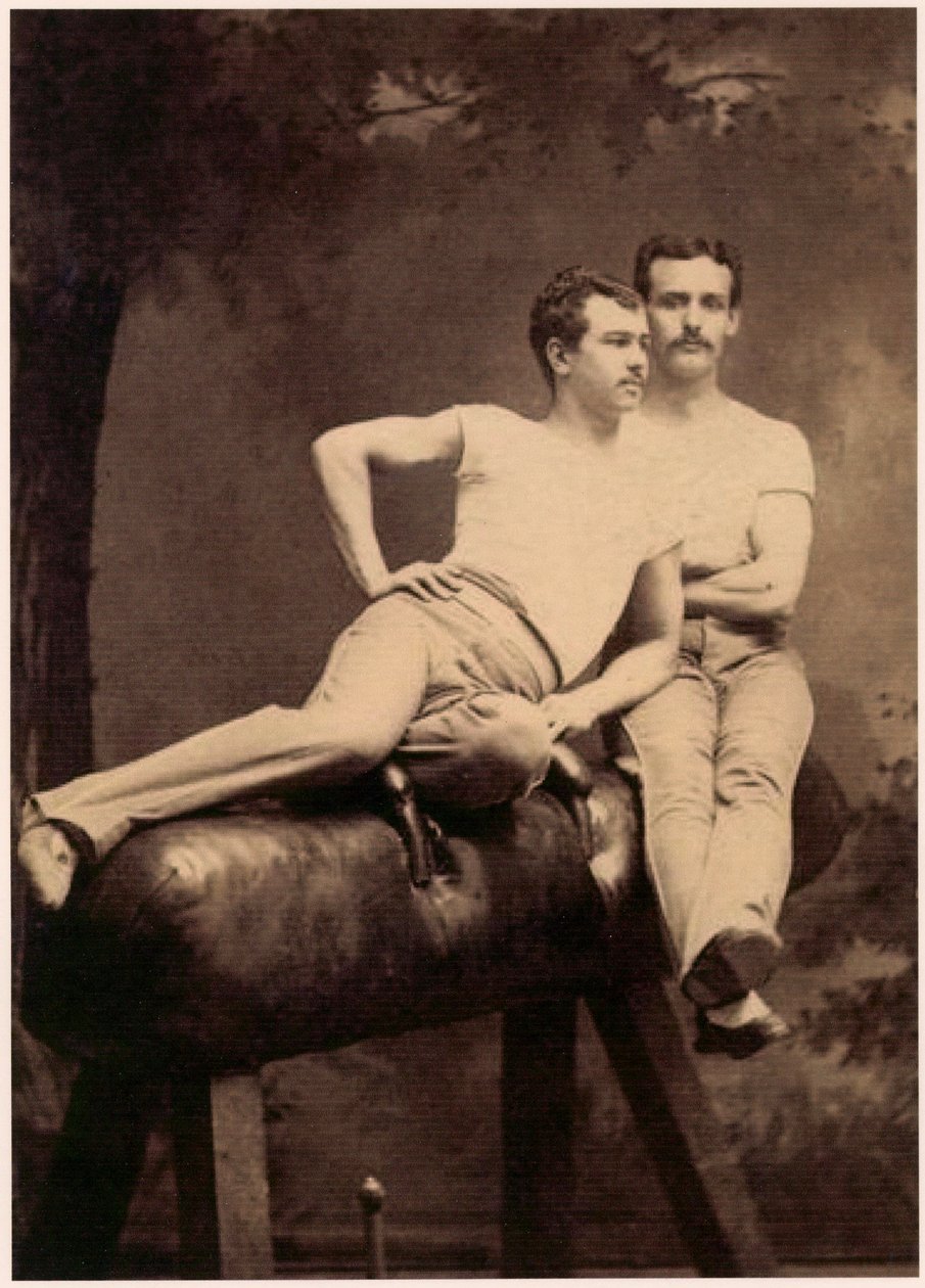 Porträtt av två gymnaster som poserar på en käpphäst, ca 1899 (svartvitt foto) av English School