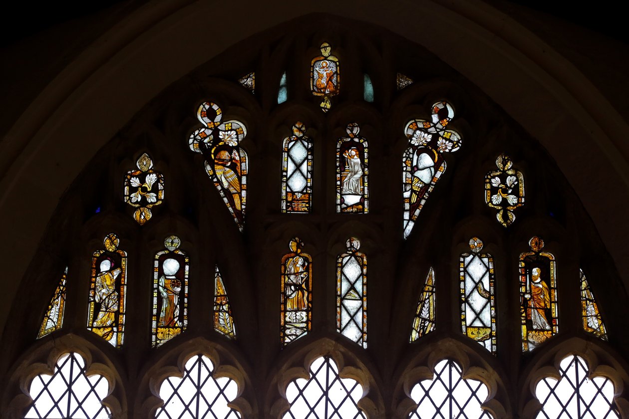 Fönster Ew som visar tracery-ljusen med Gud, Treenigheten, St Peter. St Paul, St Catherine och Gabriel: och en fågel av English School