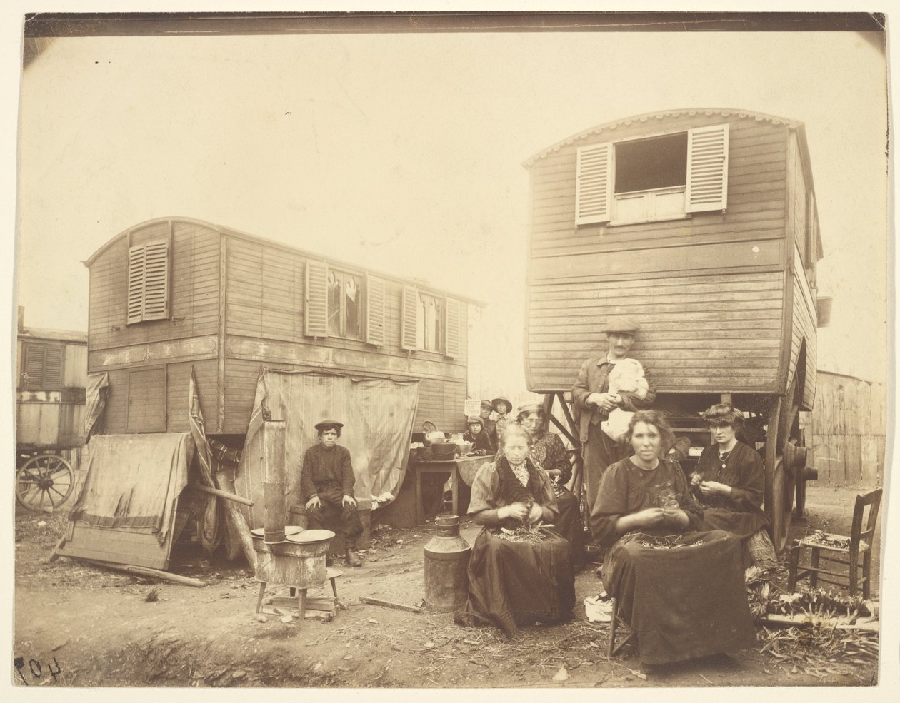 [Romer sittande utanför sina vagnar] av Eugène Atget