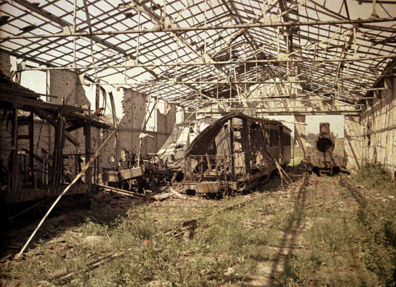 Den utbrända järnvägs- och spårvagnsgården med några skadade fordon och ett lok, Soissons, Aisne, Frankrike, 1917 (autokrom) av Fernand Cuville