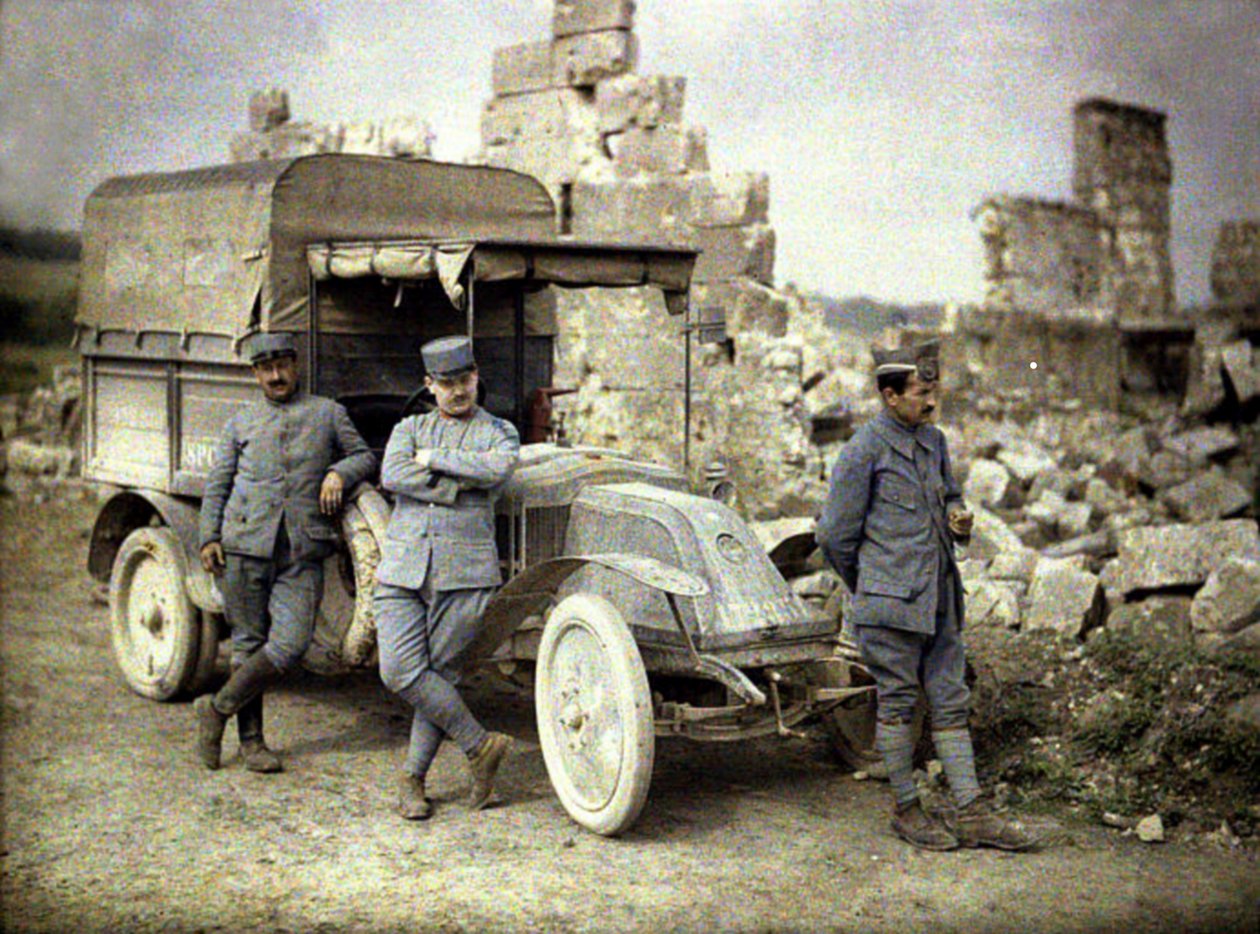 Tre franska soldater parkerade framför en hårt skadad byggnad med en liten lastbil, Aisne, Frankrike, 1917 (autokrom) av Fernand Cuville
