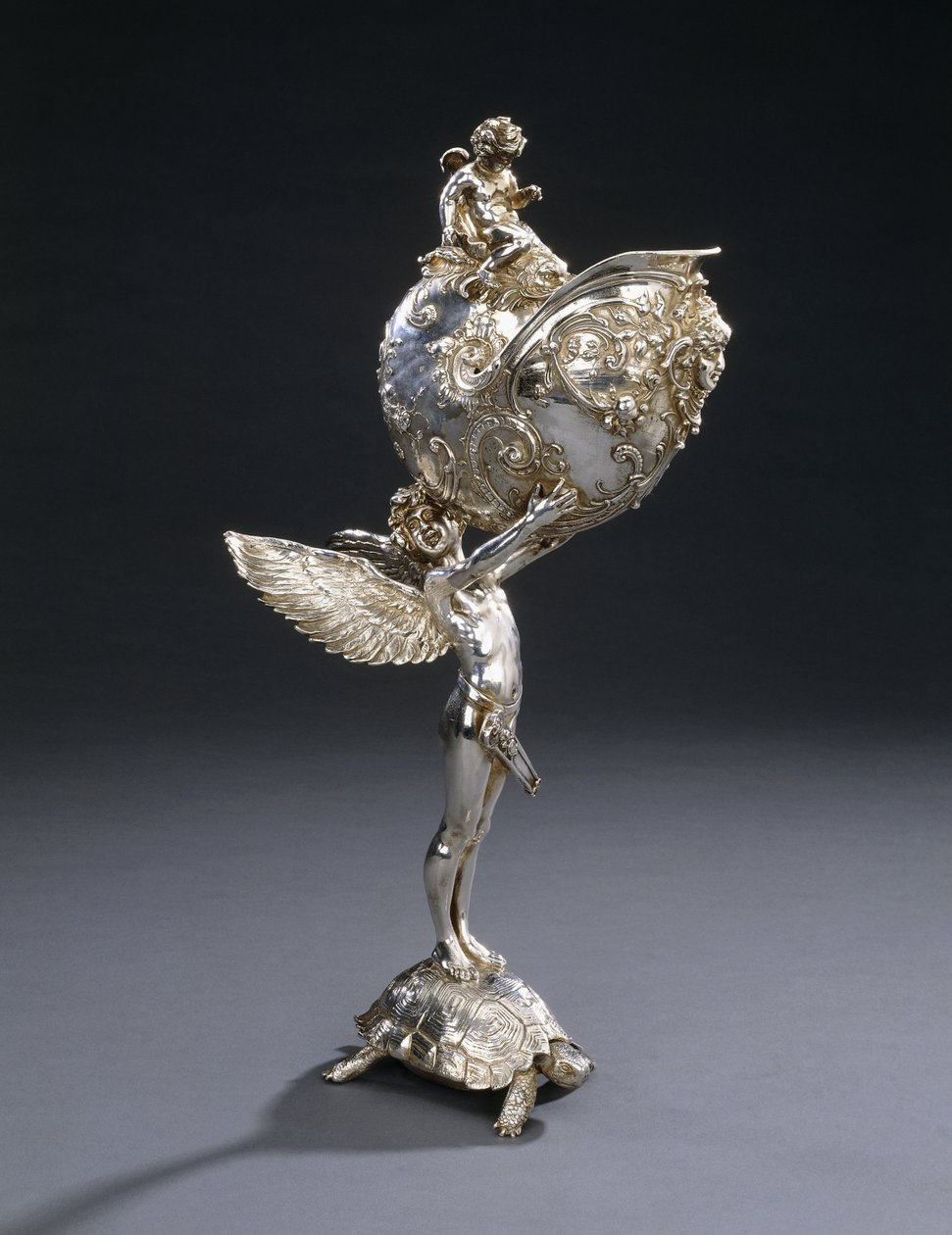 En W.M.F. skulpturell blomhållare i elektropläterad brons, designad av Franz von Stuck, modellerad som en bevingad ungdom som står på en sköldpadda och håller upp ett nautilusskal, ca 1906 av Franz von Stuck