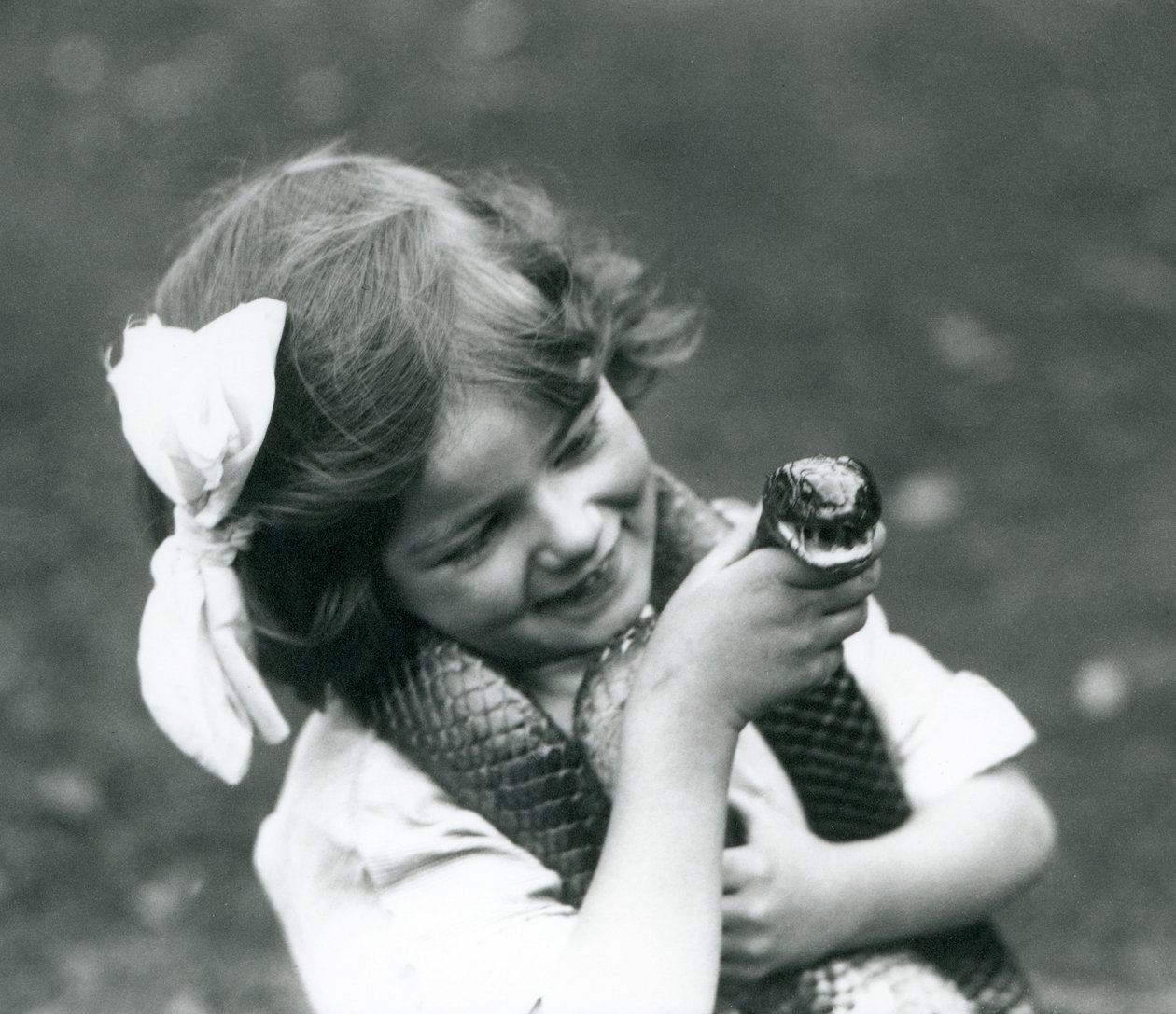 En ung flicka Betty som håller en Eastern Indigo Snake, London Zoo, 1924 av Frederick William Bond