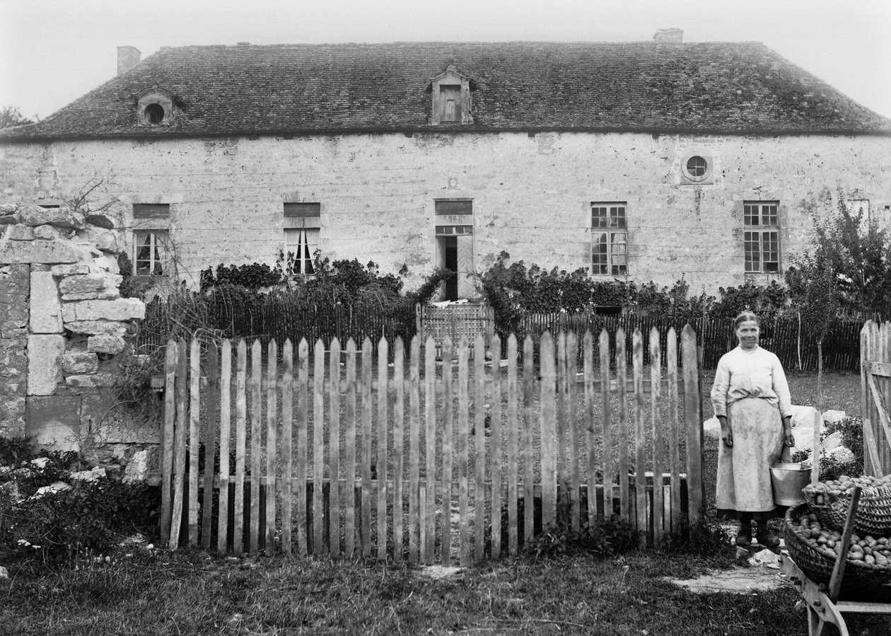 En bondkvinna framför sin gård, i närheten av Bourmont i Haute Marne. Fotografering sent 1800-tal. Ducos samling. av French Photographer