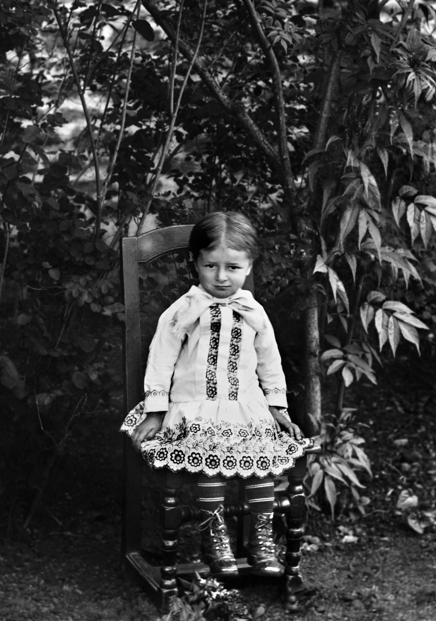 Porträtt av en liten flicka från Bourmont i Haute Marne, sittande i trädgården till Abbey of Septfontaines. Fotografering sent 1800-tal. Ducos samling. av French Photographer