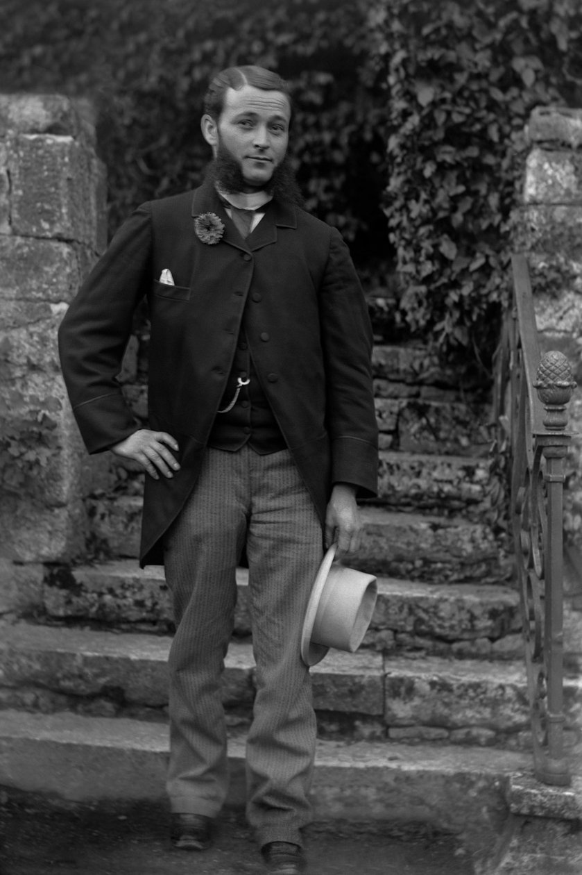 Porträtt av en ung man från Bourmont i Haute Marne, iklädd cockaden av värnpliktiga vid buttonniere, poserande i trädgården till Abbey of Septfontaines. Fotografi sent 1800-tal. Ducos samling. av French Photographer