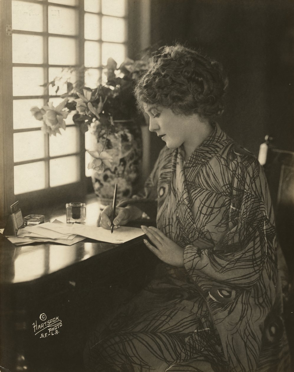 Mary Pickford, iklädd kimono, skriver vid ett skrivbord, ca 1918 (s/v foto) av Bartolome Esteban and studio Murillo